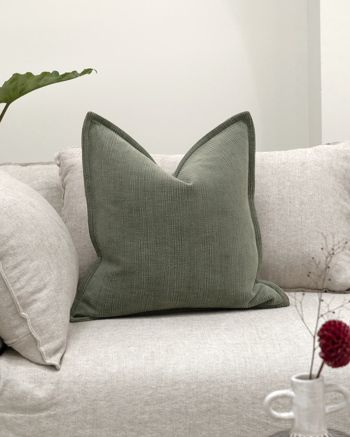 Macey Jade cushion in grey and green, shown in a lifestyle front view as image 2