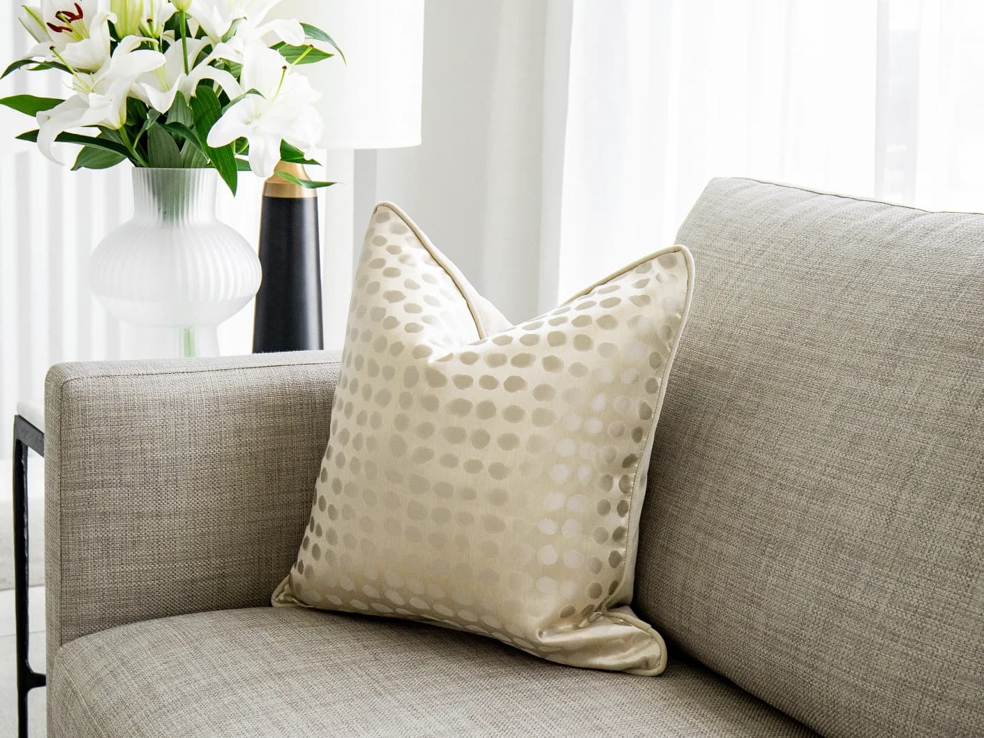 Marissa Bianca single cushions in beige and silver, shown in a lifestyle front view