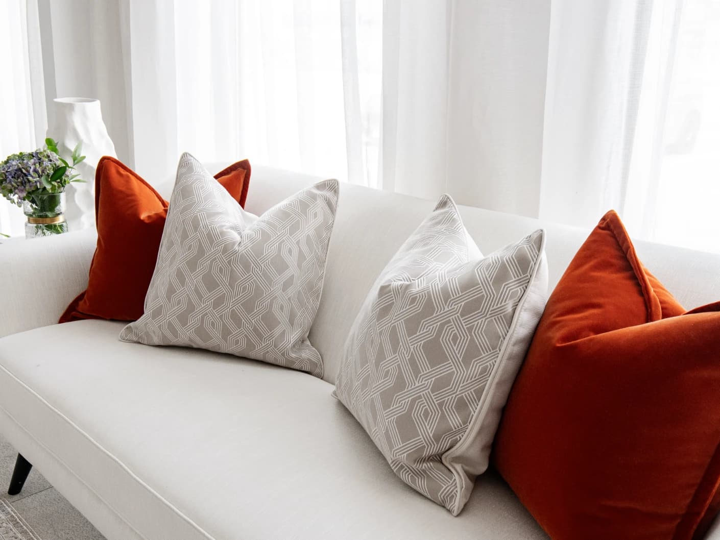 Marites Bundle bundle cushions in tan, orange, beige and white, shown in a lifestyle front view