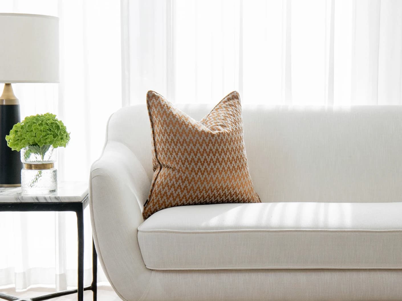 Maxene Hodler single cushions in orange, shown in a lifestyle front view