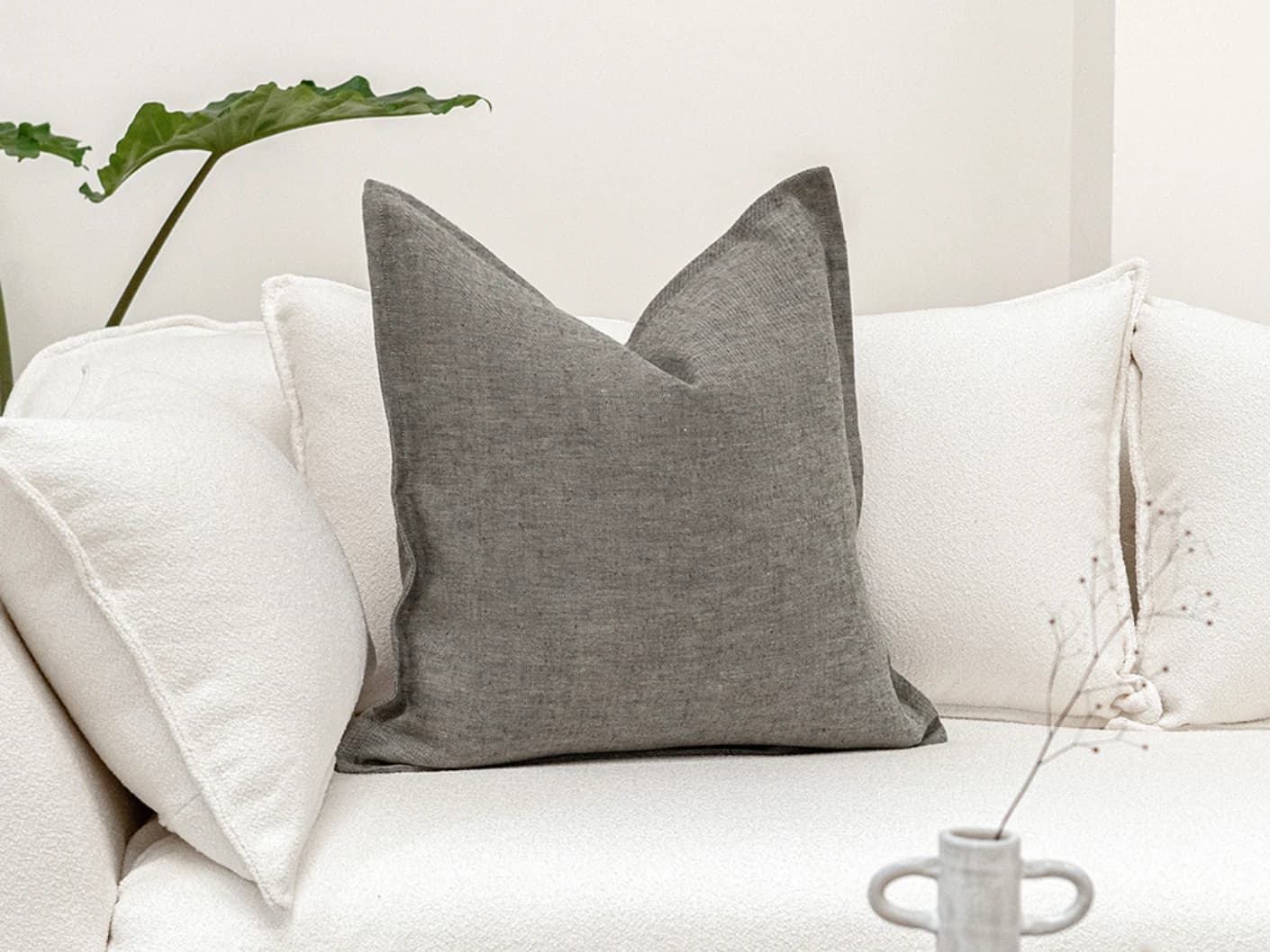Mel Ash single cushions in grey, shown in a lifestyle front view