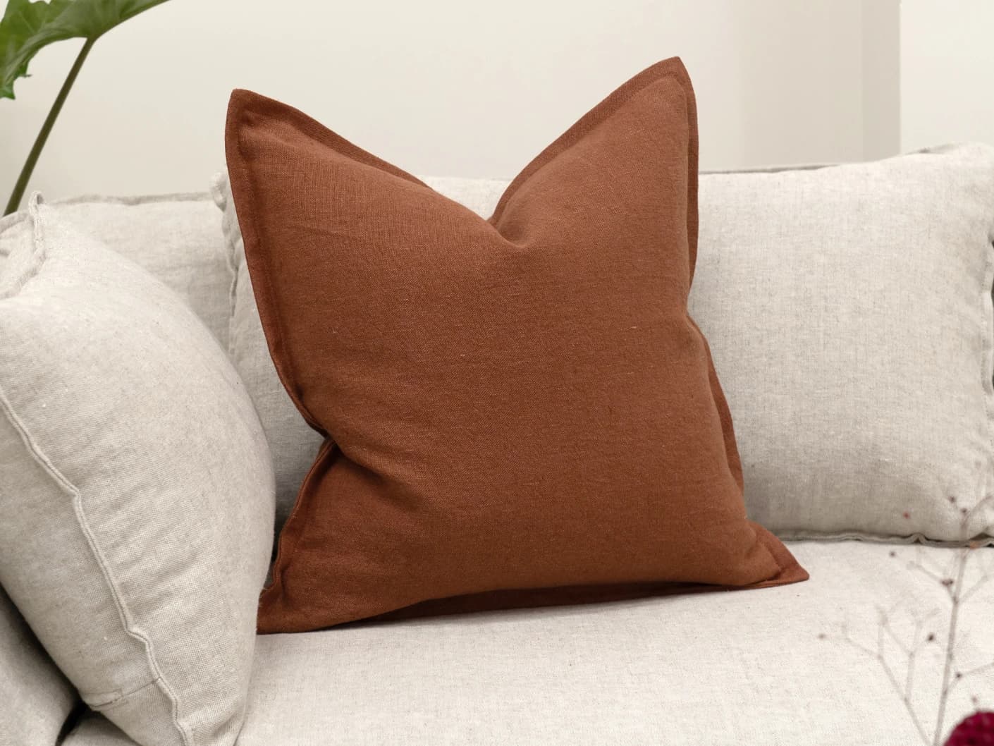 Mel Brick single cushions in rust, shown in a lifestyle front view