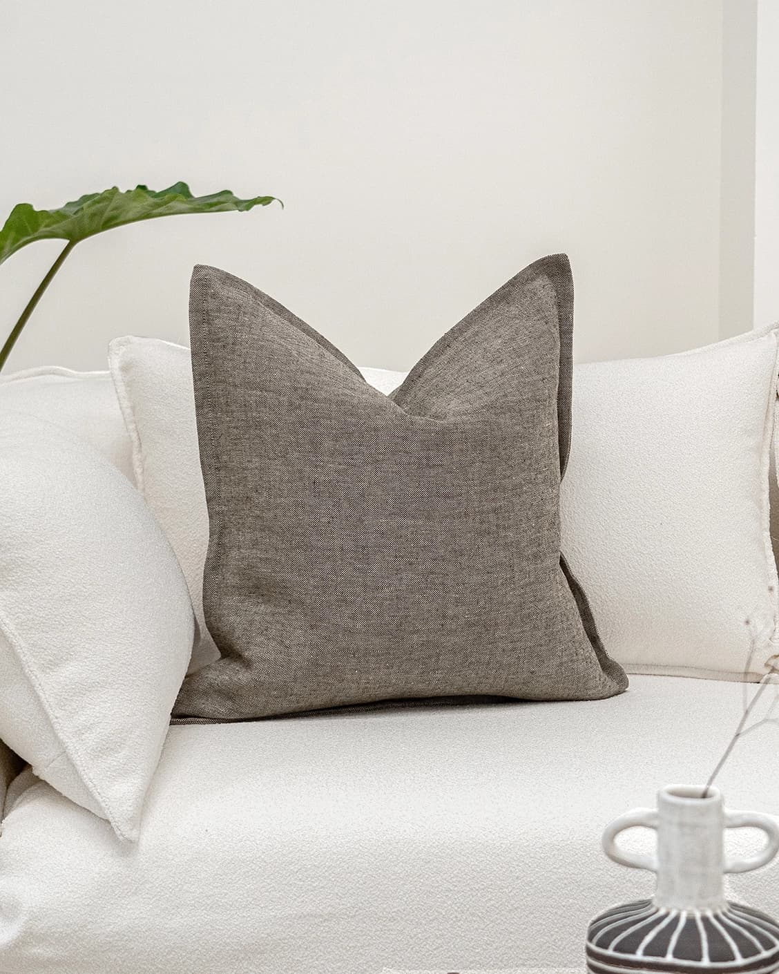 Mel Smoke cushion in linen, grey and charcoal, shown in a lifestyle front view as image 2