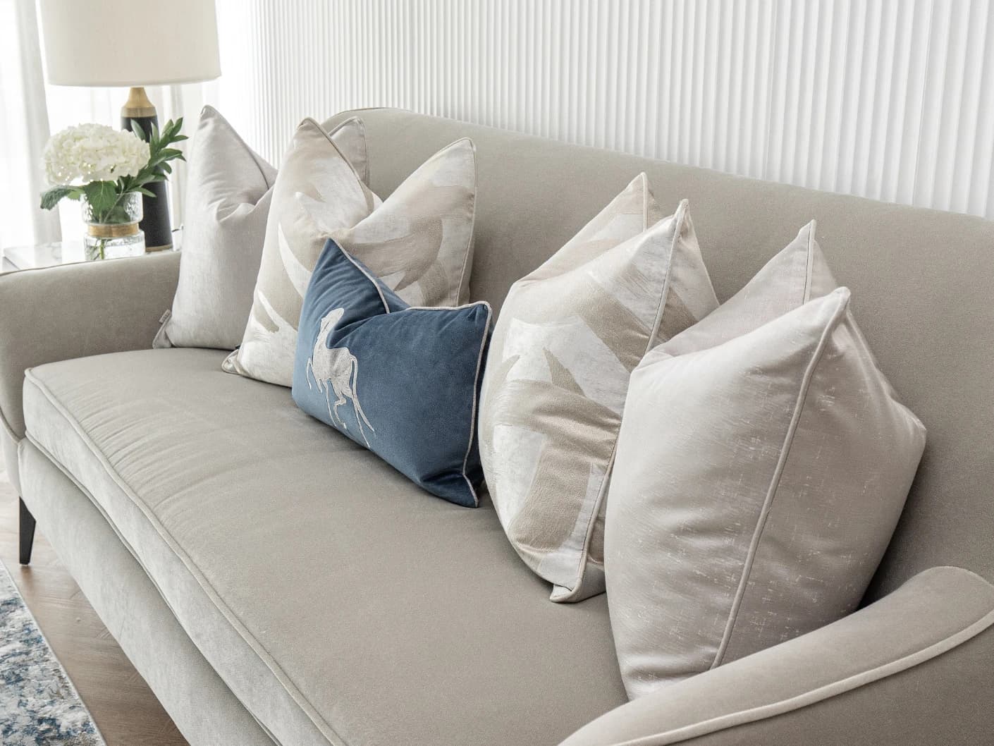 Miguel Bundle bundle cushions in silver, beige and blue, shown in a lifestyle front view