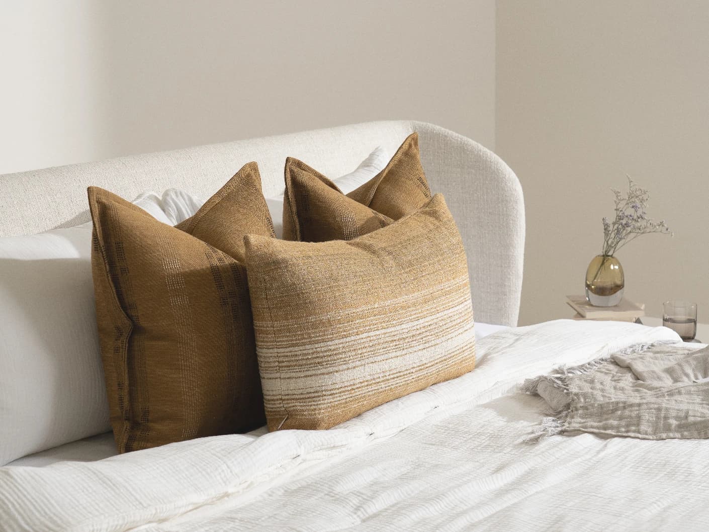 Mihi Bundle bundle cushions in ochre and cream, shown in a lifestyle left view