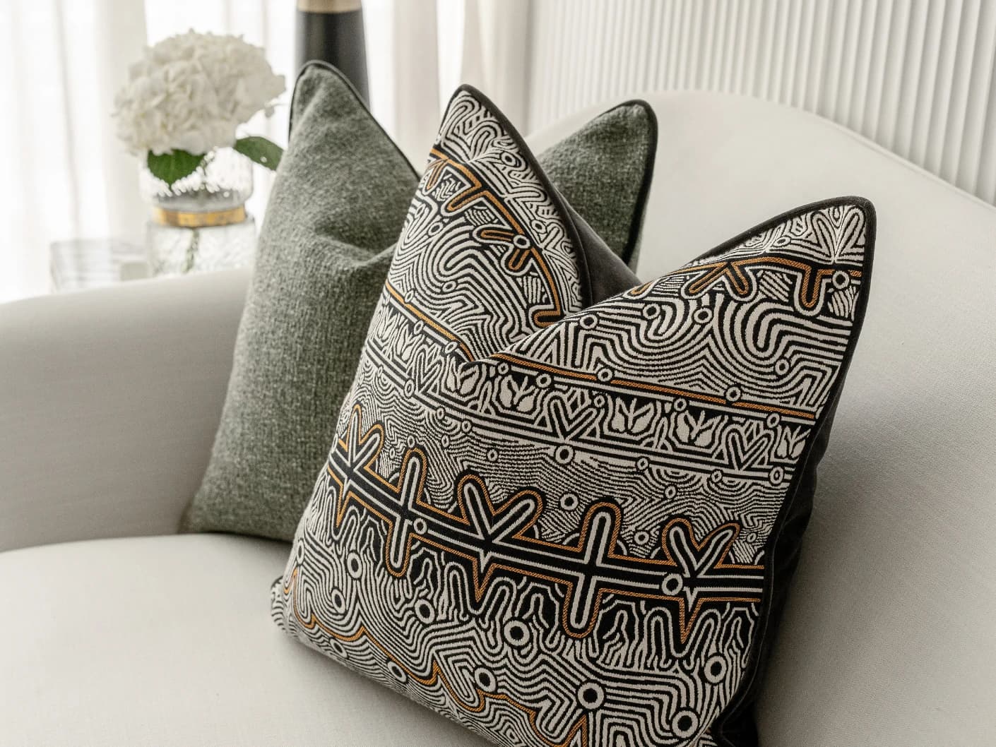 Mika Bundle bundle cushions in black, silver and green, shown in a lifestyle front view