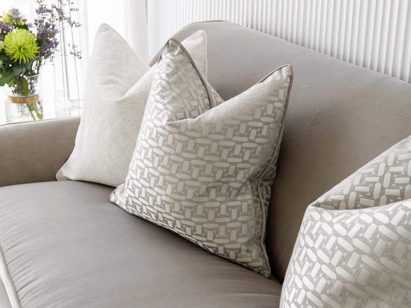 Nadia Bundle bundle cushions in white, beige and silver, shown in a lifestyle front view