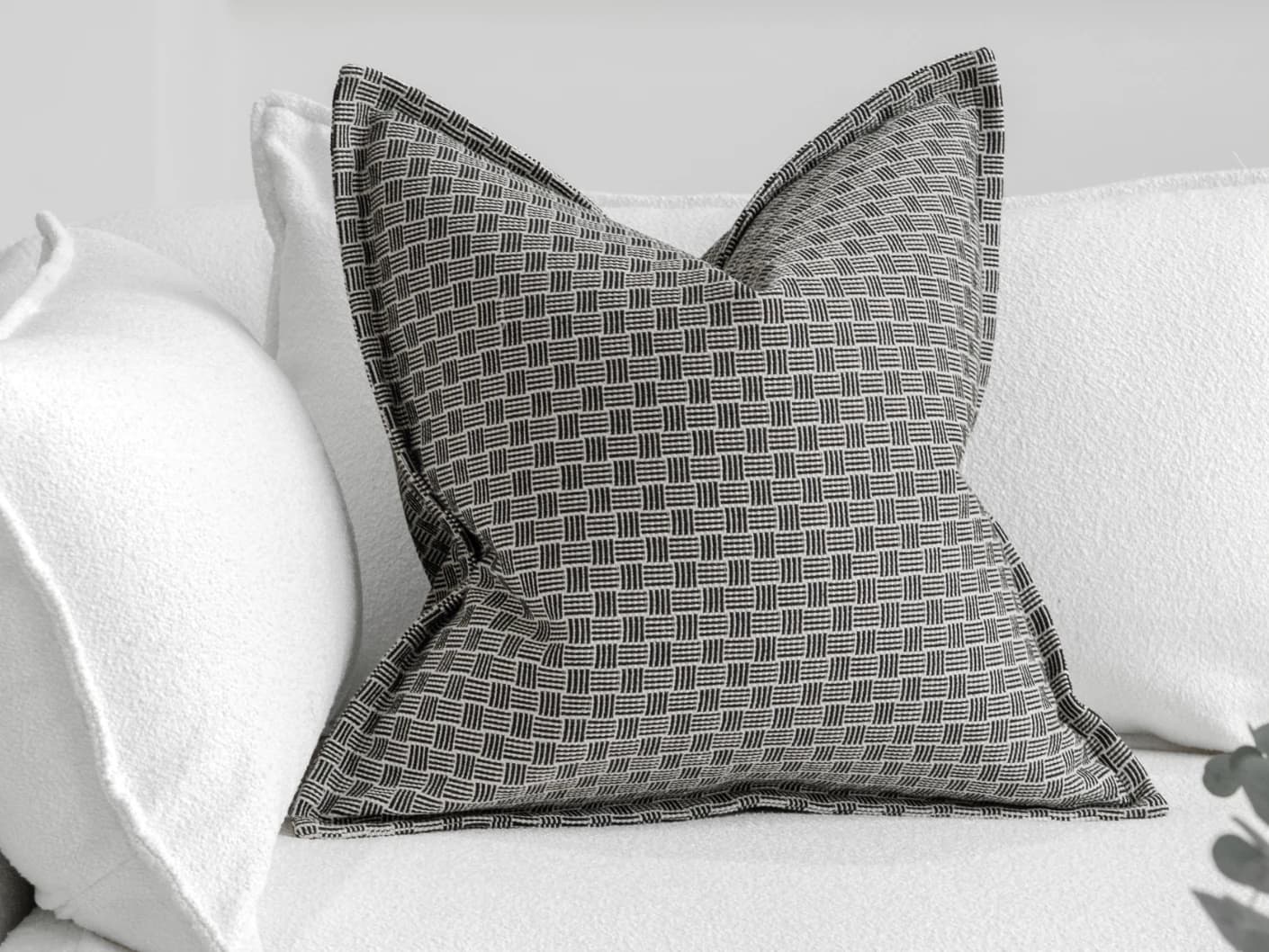 Naomi Steele single cushions in grey, shown in a lifestyle front view