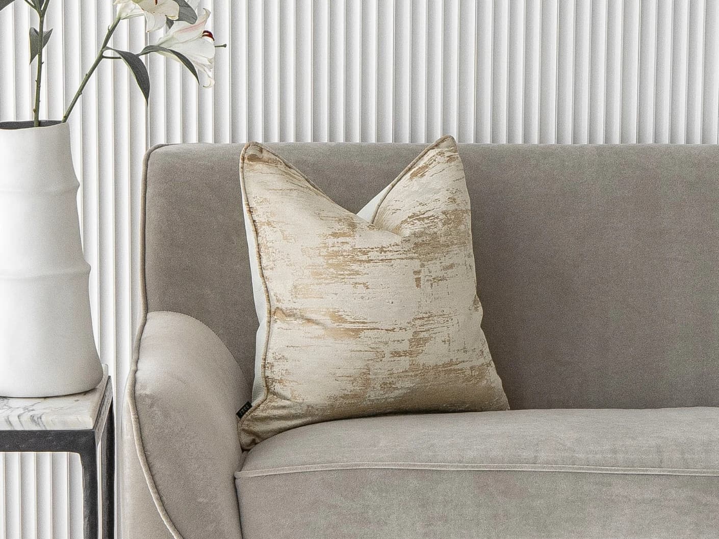Neri Klimt single cushions in gold and beige, shown in a lifestyle front view