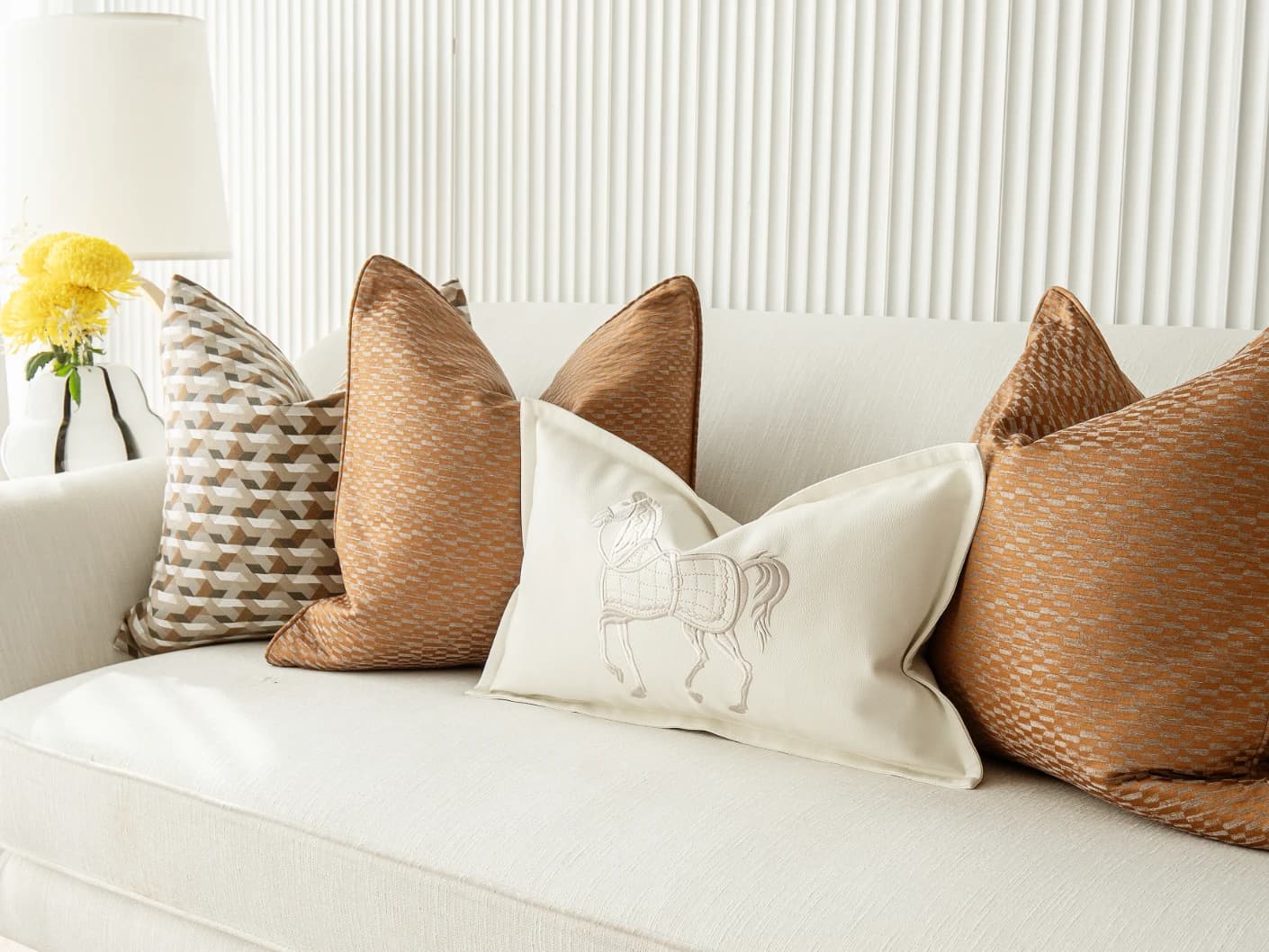 Nerola Bundle bundle cushions in orange, beige and white, shown in a lifestyle front view