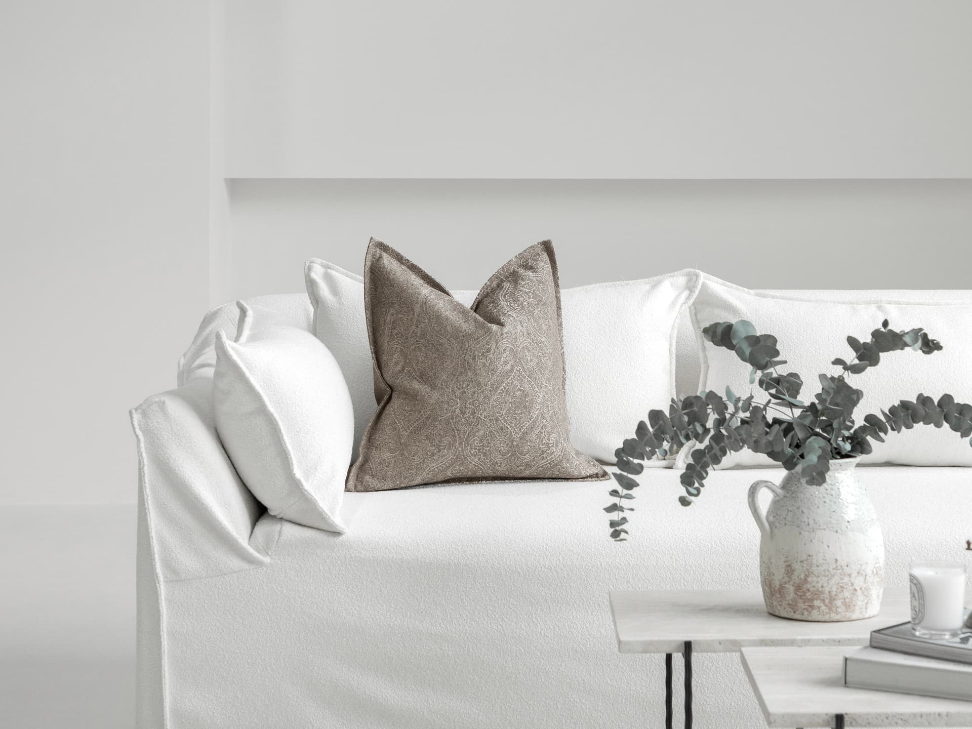 Nia Laurent single cushions in taupe and grey, shown in a lifestyle front view