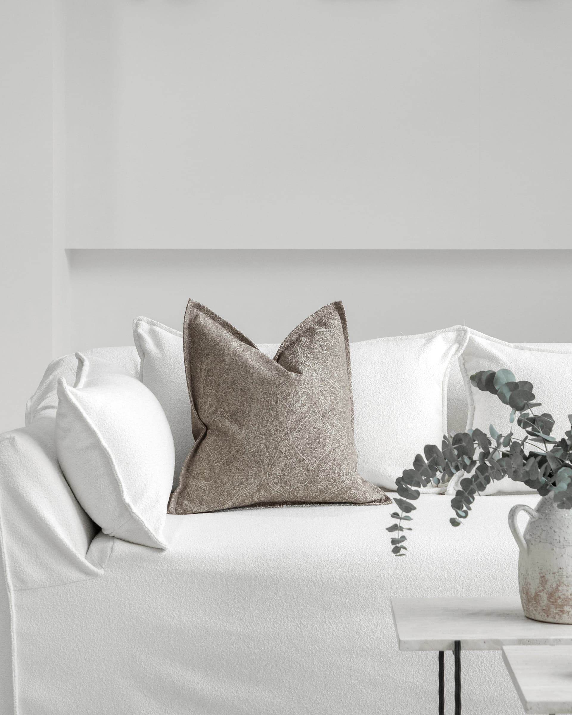 Nia Laurent cushion in taupe and grey, shown in a lifestyle front view as image 3