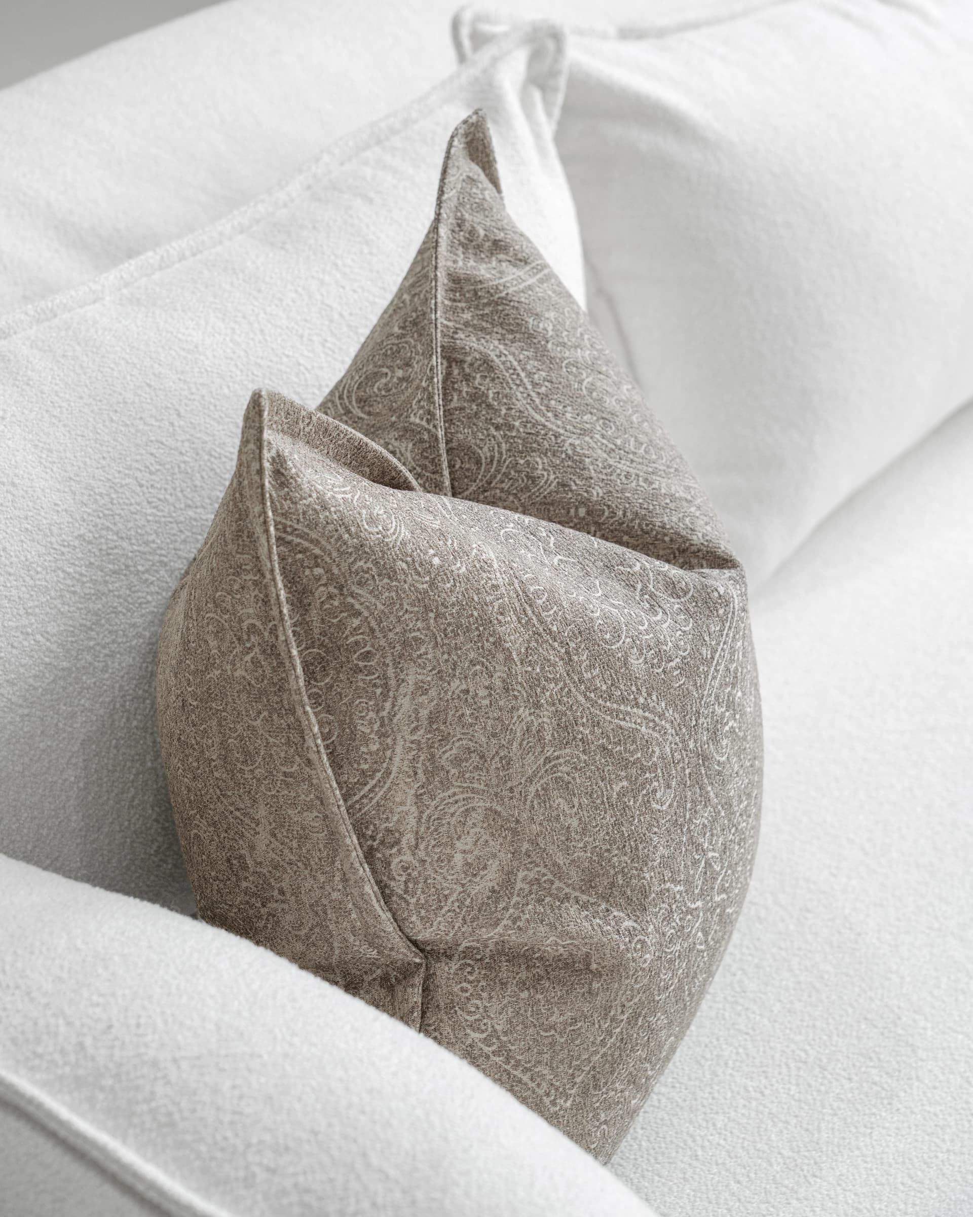 Nia Laurent cushion in taupe and grey, shown in a lifestyle top view as image 5