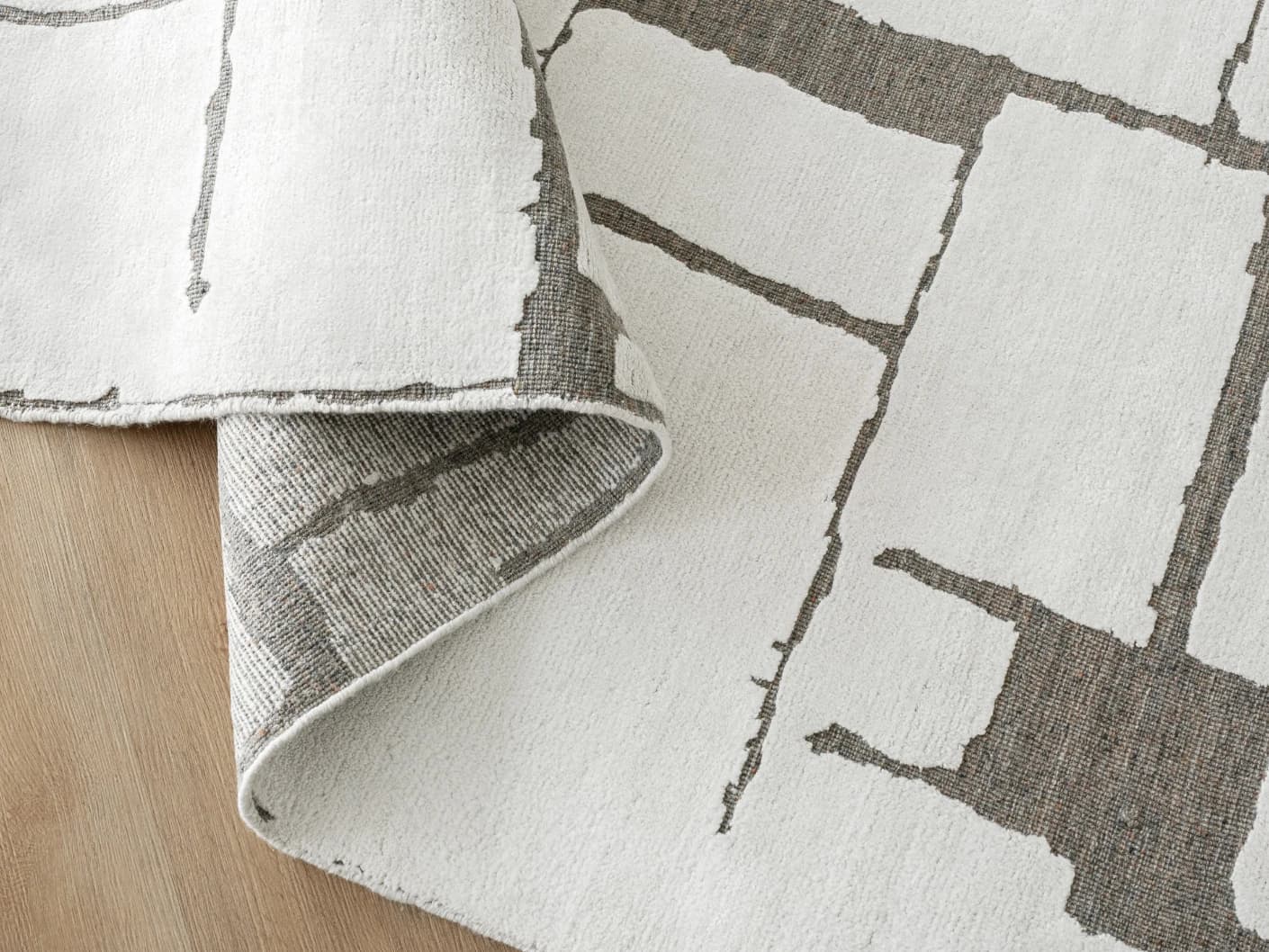 Nico Sandy carpets in sandy, ivory, grey and brown, shown in a product close-up view