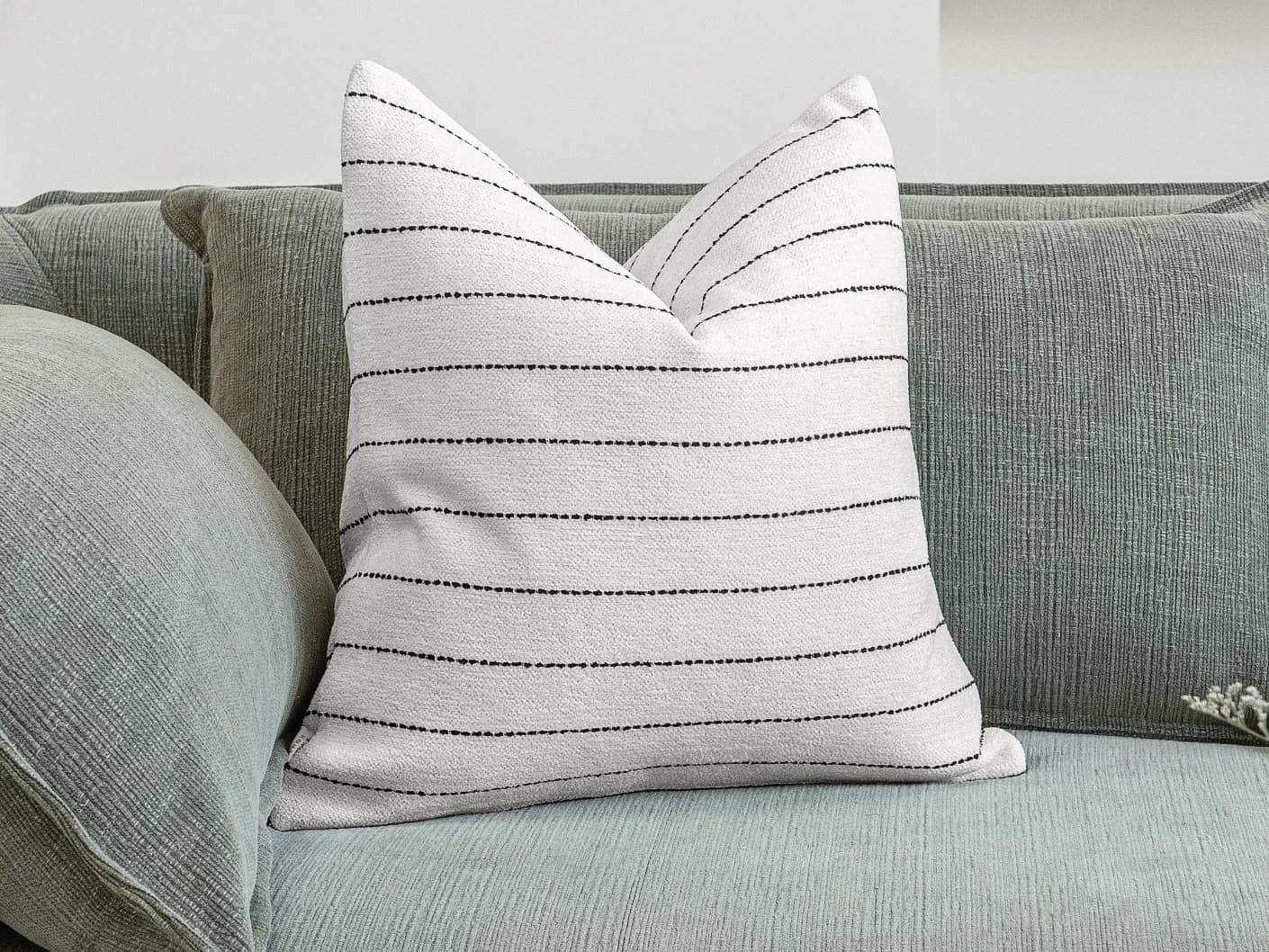 Noa Bianca single cushions in black and ivory, shown in a lifestyle front view