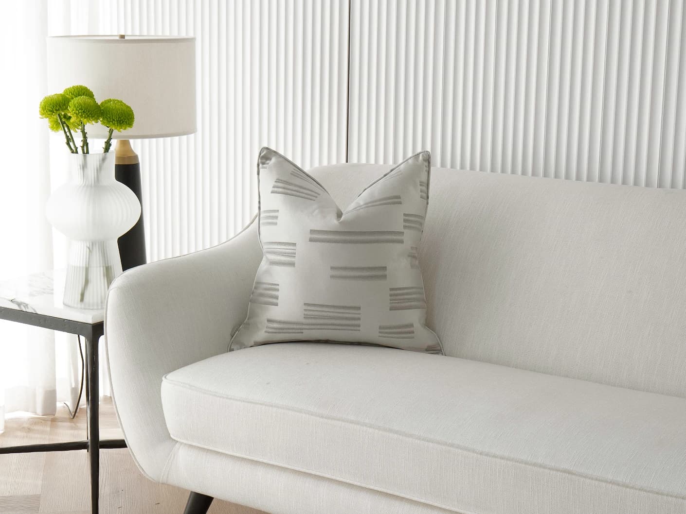 Nolan Laurent single cushions in silver and grey, shown in a lifestyle front view