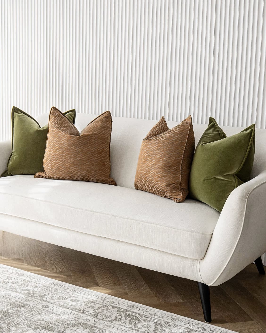 Octavia Bundle cushion in green and orange, shown in a lifestyle front view as image 2
