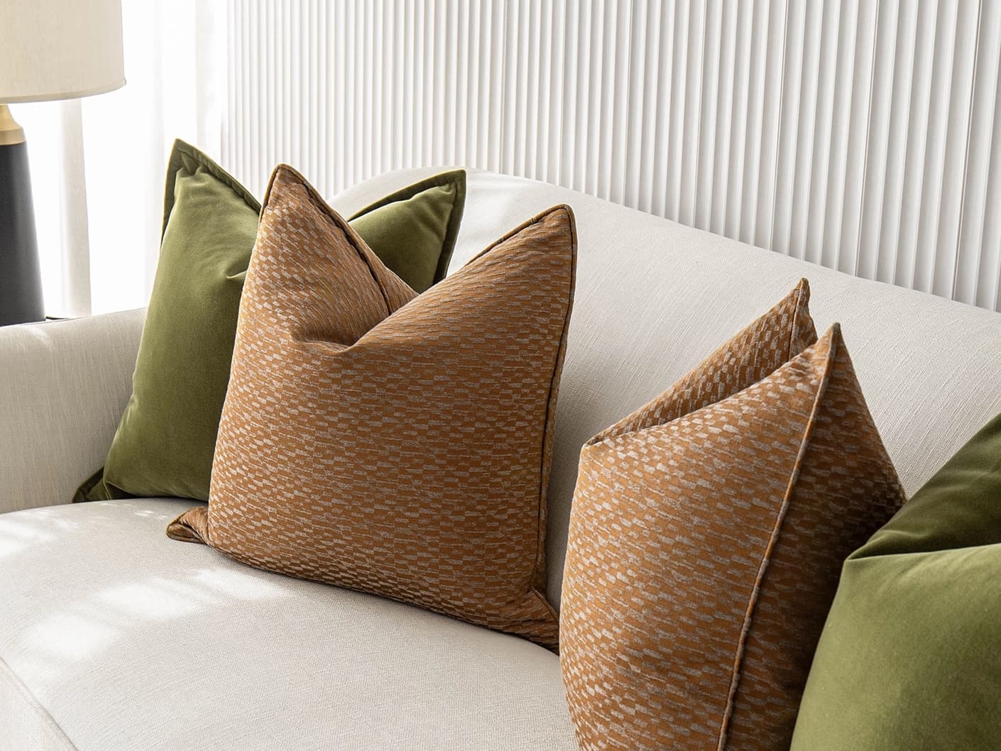 Octavia Bundle bundle cushions in green and orange, shown in a lifestyle front view