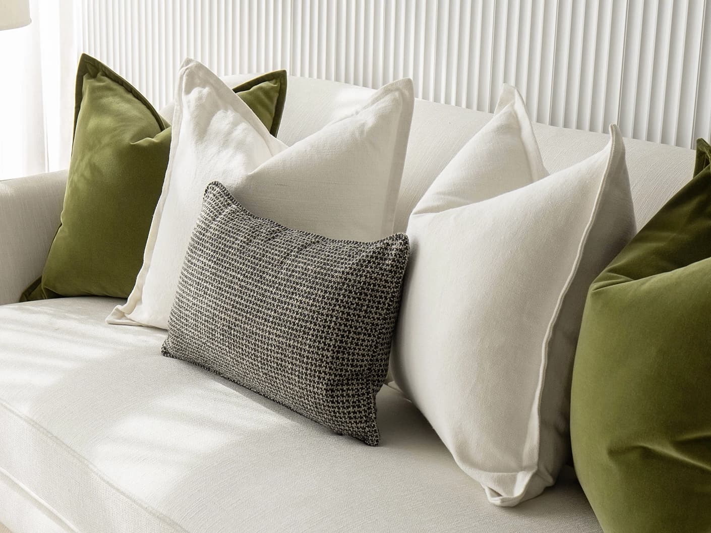 Oona Bundle bundle cushions in white, green and black, shown in a lifestyle front view