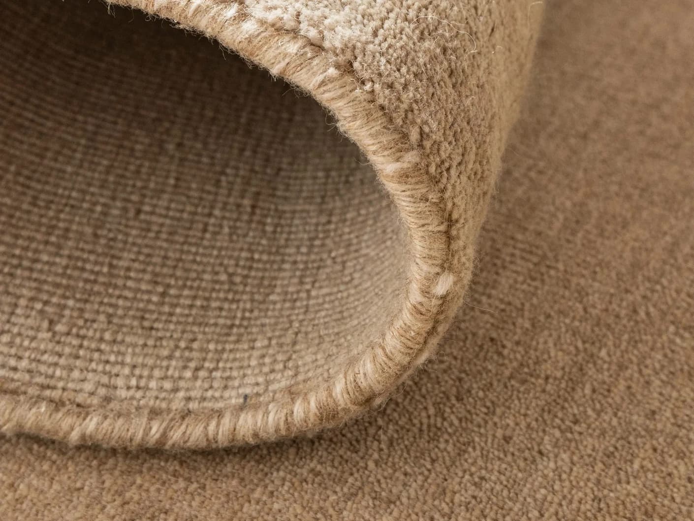 Oscar Sandy carpets in beige, shown in a lifestyle close-up top view as image 1