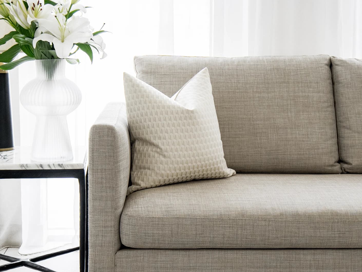 Paul Bianca single cushions in white and beige, shown in a lifestyle front view