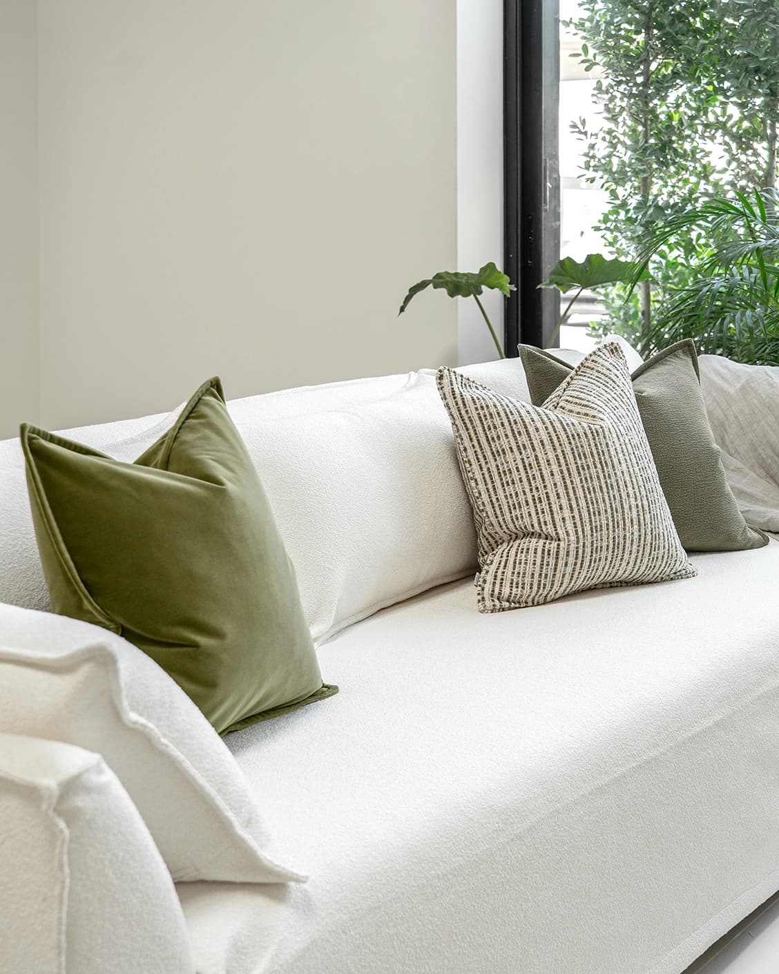 Praveen Bundle bundle cushions in green and cream, shown in a lifestyle front view