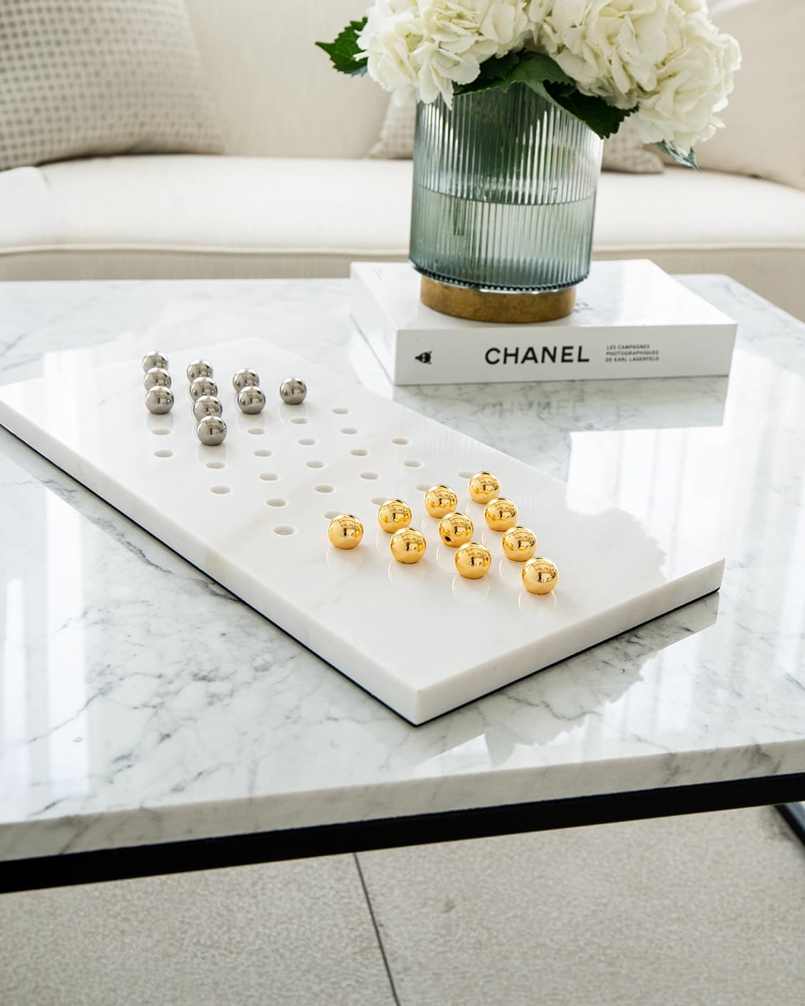 Rally Malcolm statues and sculptures in gold, white and silver, shown in a lifestyle left view