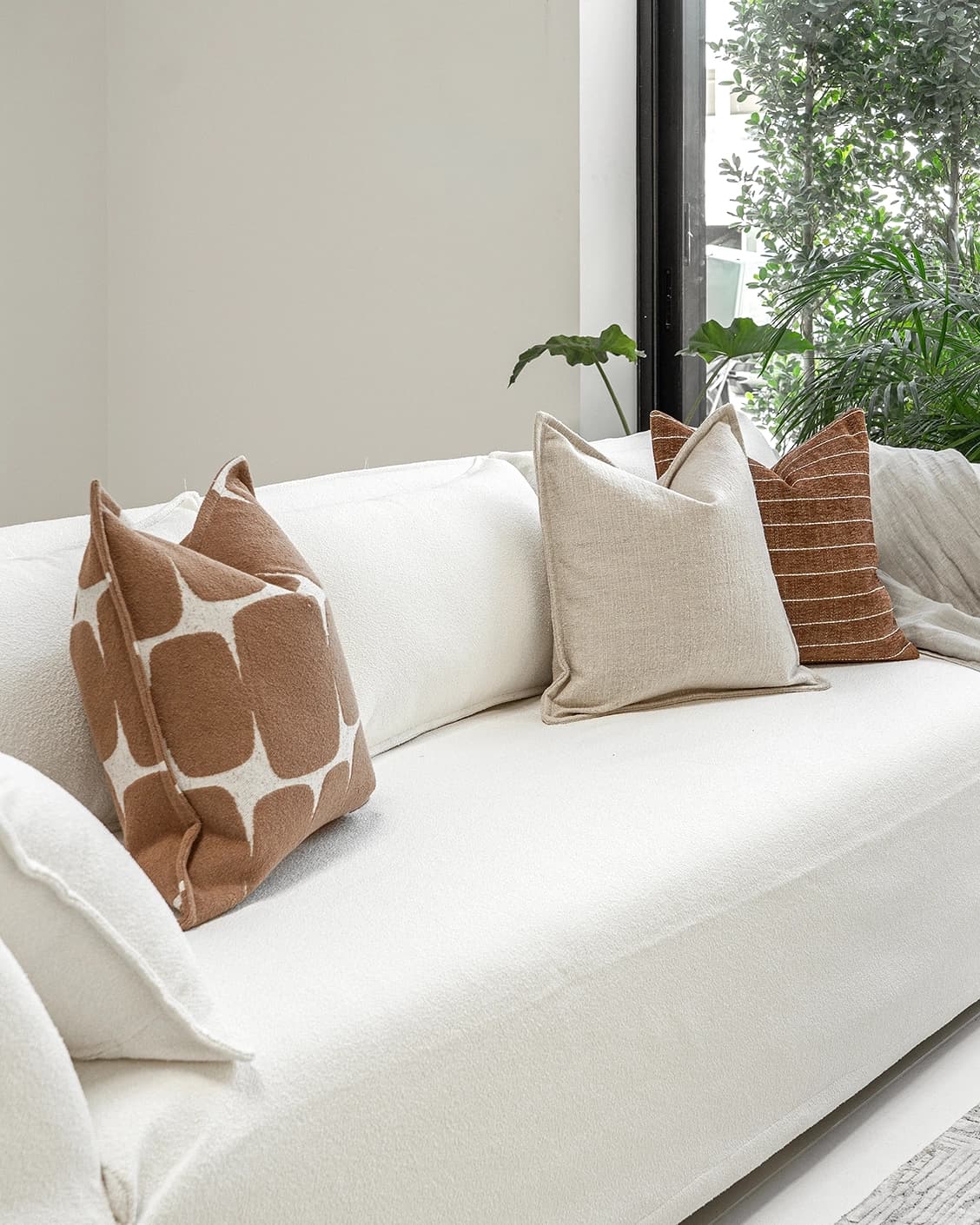 Ranjith Bundle cushion in beige and brown, shown in a lifestyle left view as image 2
