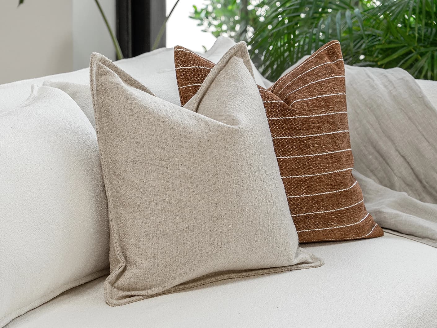 Ranjith Bundle bundle cushions in beige and brown, shown in a lifestyle front view