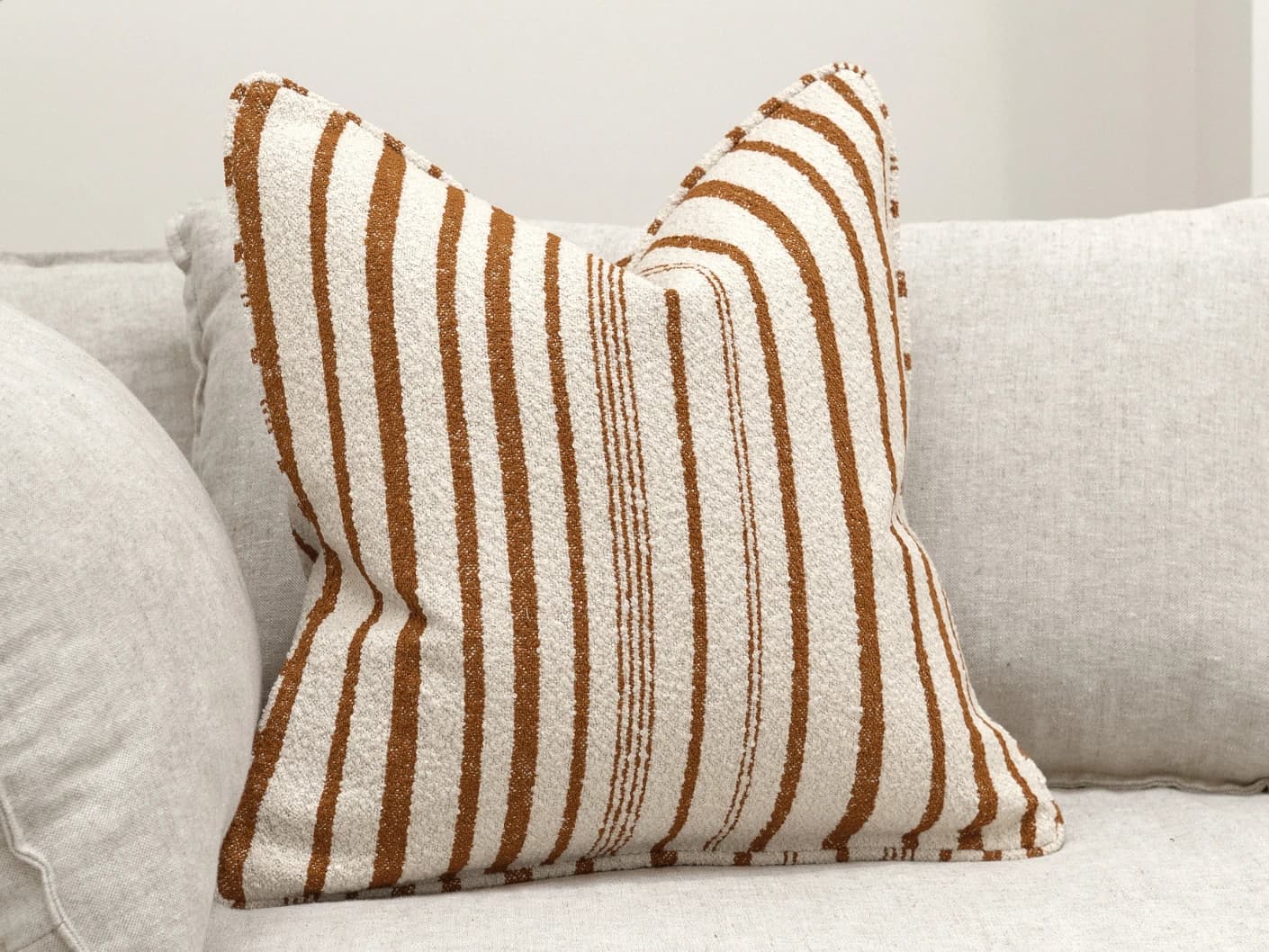 Raya Hodler single cushions in ivory, shown in a lifestyle front view