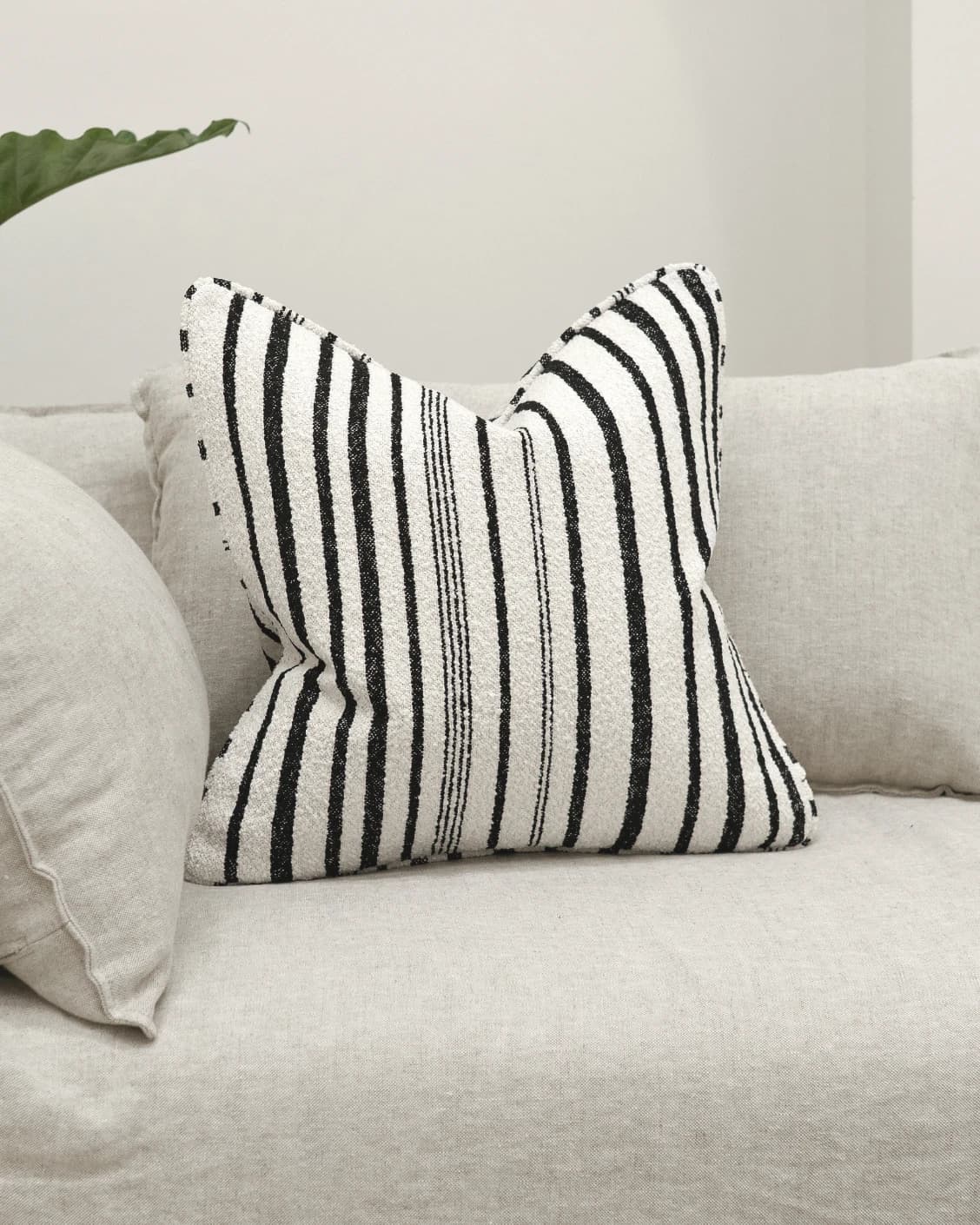 Raya Steele cushion in ivory and charcoal, shown in a lifestyle front view as image 2