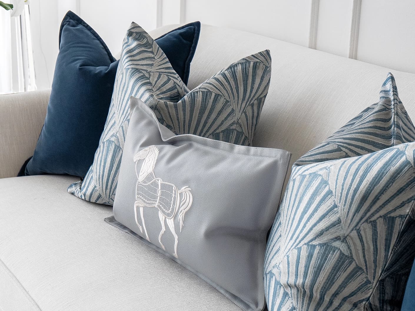 Remi Bundle bundle cushions in blue, silver and white, shown in a lifestyle front view