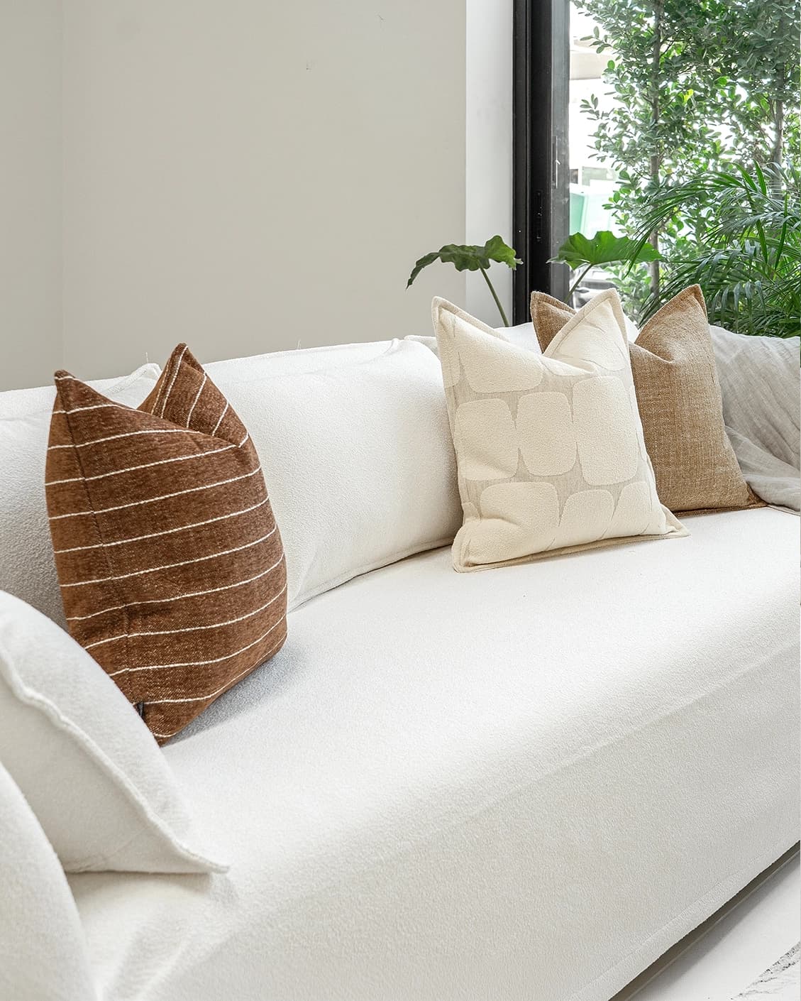 Rennie Bundle cushion in brown and white, shown in a lifestyle left view as image 2
