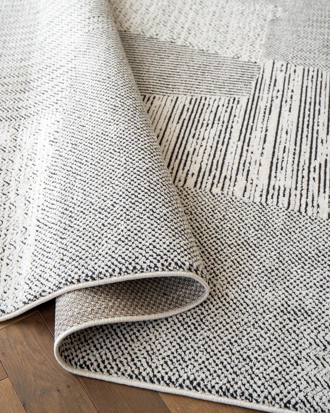 Renzo Dusty carpet in black and white, shown in a lifestyle close-up as image 4