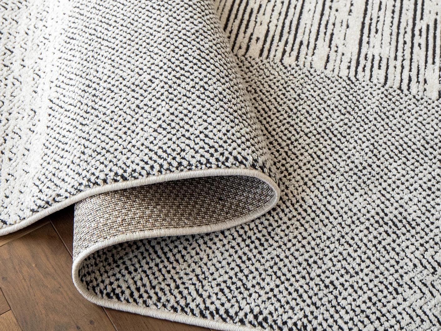 Renzo Dusty carpet in black and white, shown in a lifestyle close-up as image 4