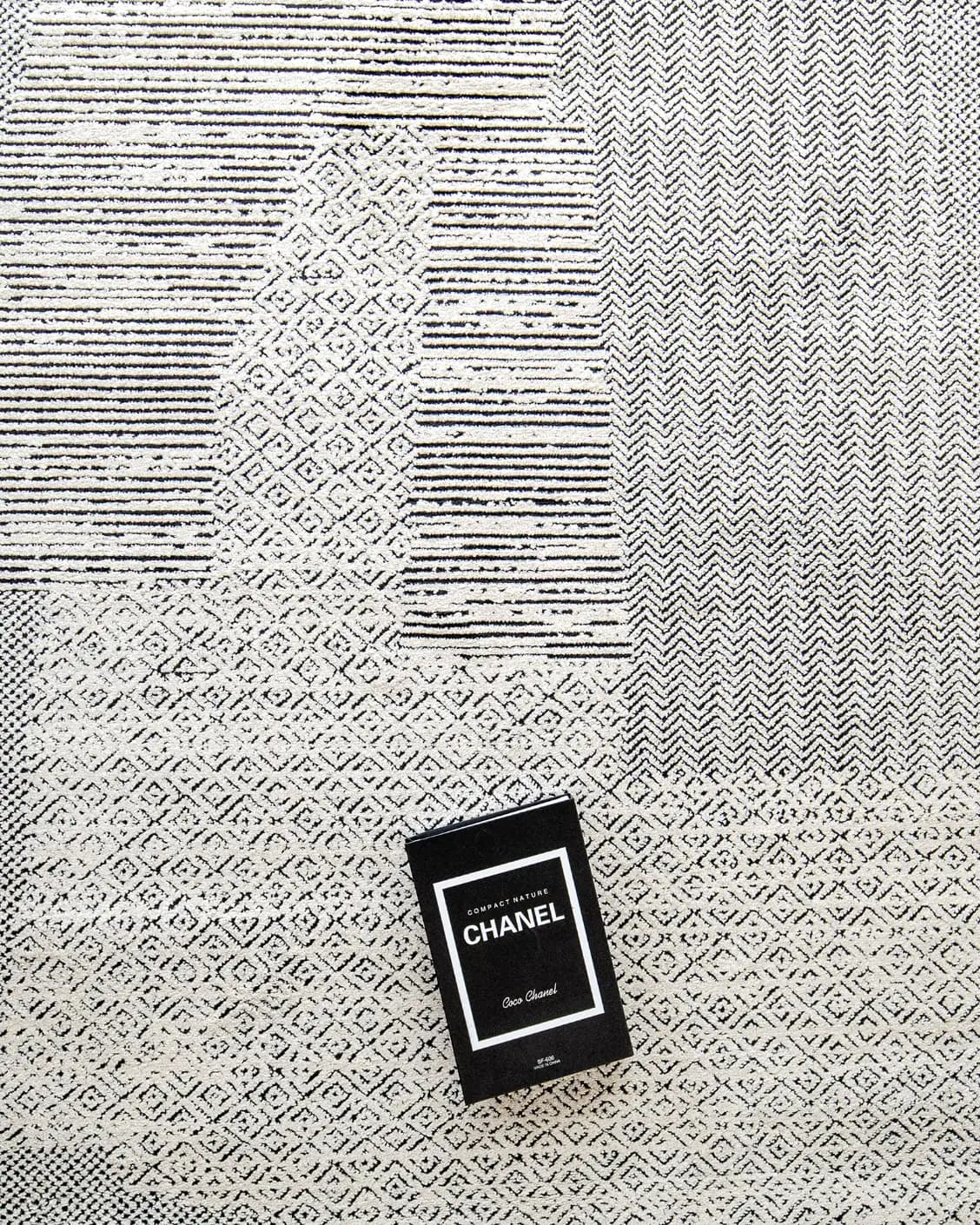 Renzo Dusty carpet in black and white, shown in a lifestyle top view as image 8