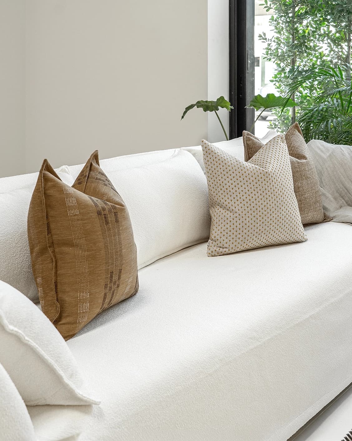 Romi Bundle cushion in brown and beige, shown in a lifestyle left view as image 2