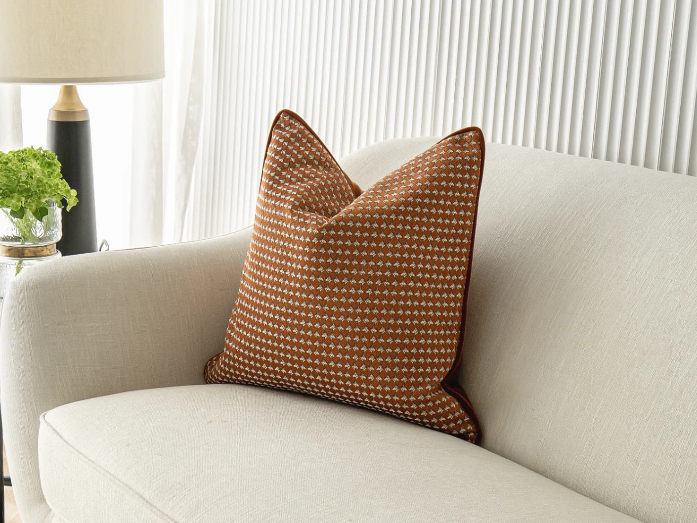 Rory Caravaggio single cushions in orange, shown in a lifestyle front view