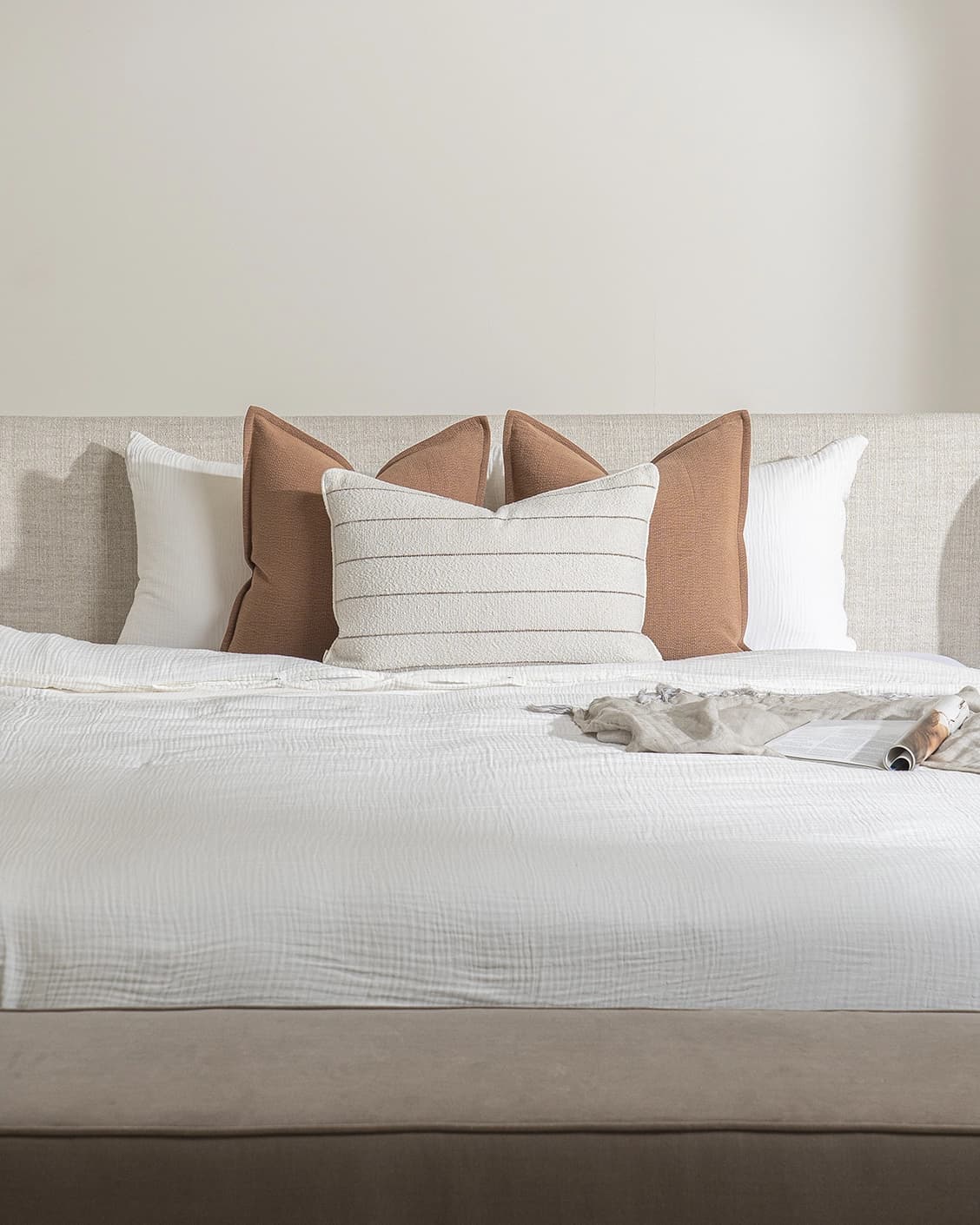 Rosh Bundle cushion in rust and ivory, shown in a lifestyle front view as image 2