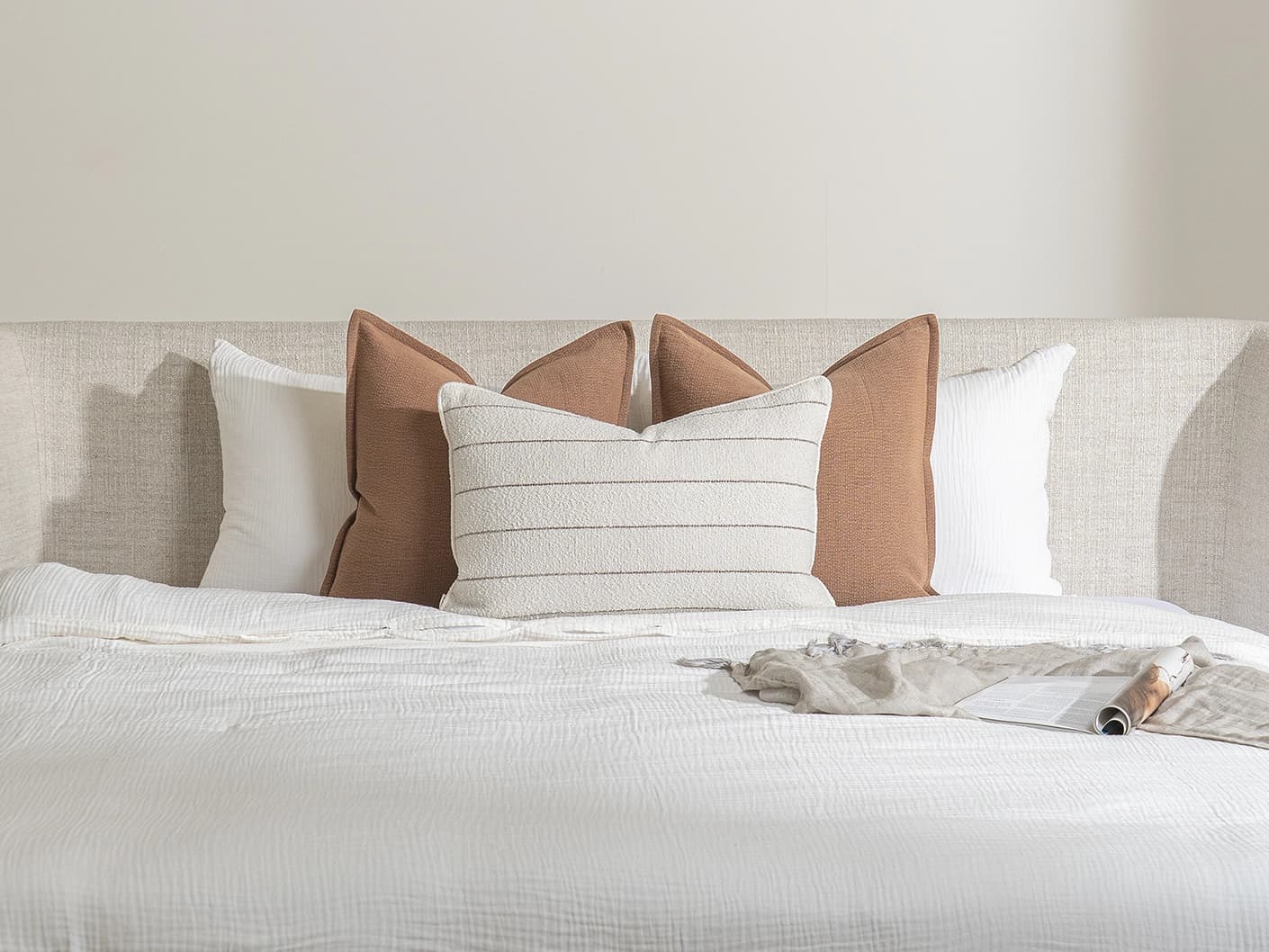 Rosh Bundle bundle cushions in rust and ivory, shown in a lifestyle front view