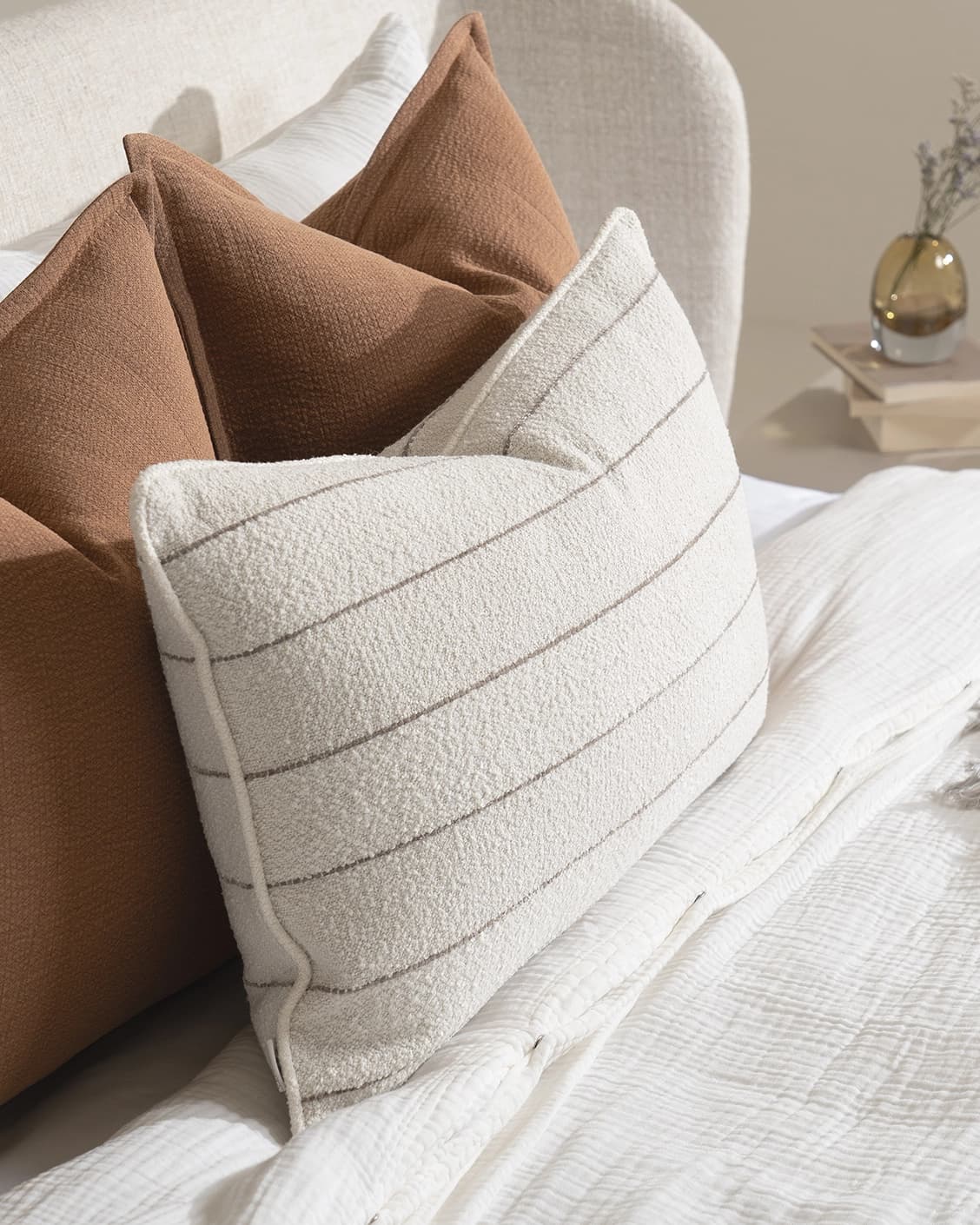 Rosh Bundle cushion in rust and ivory, shown in a lifestyle left view as image 7