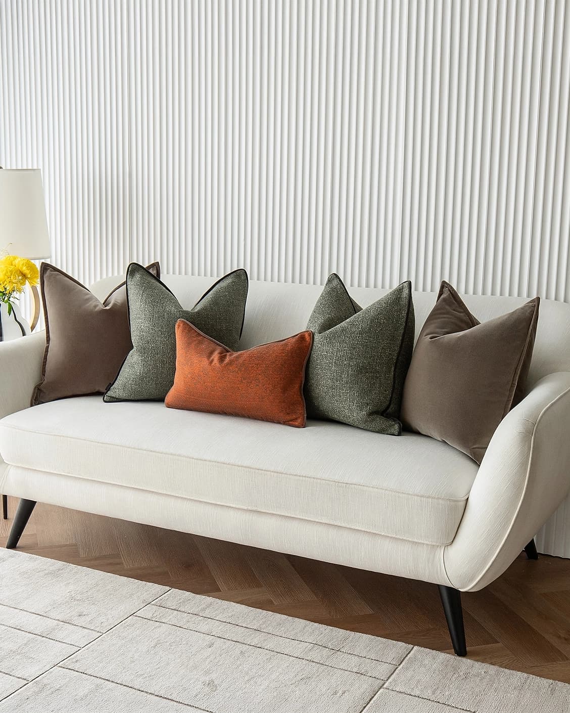 Roux Bundle cushion in orange, brown and green, shown in a lifestyle right view as image 2