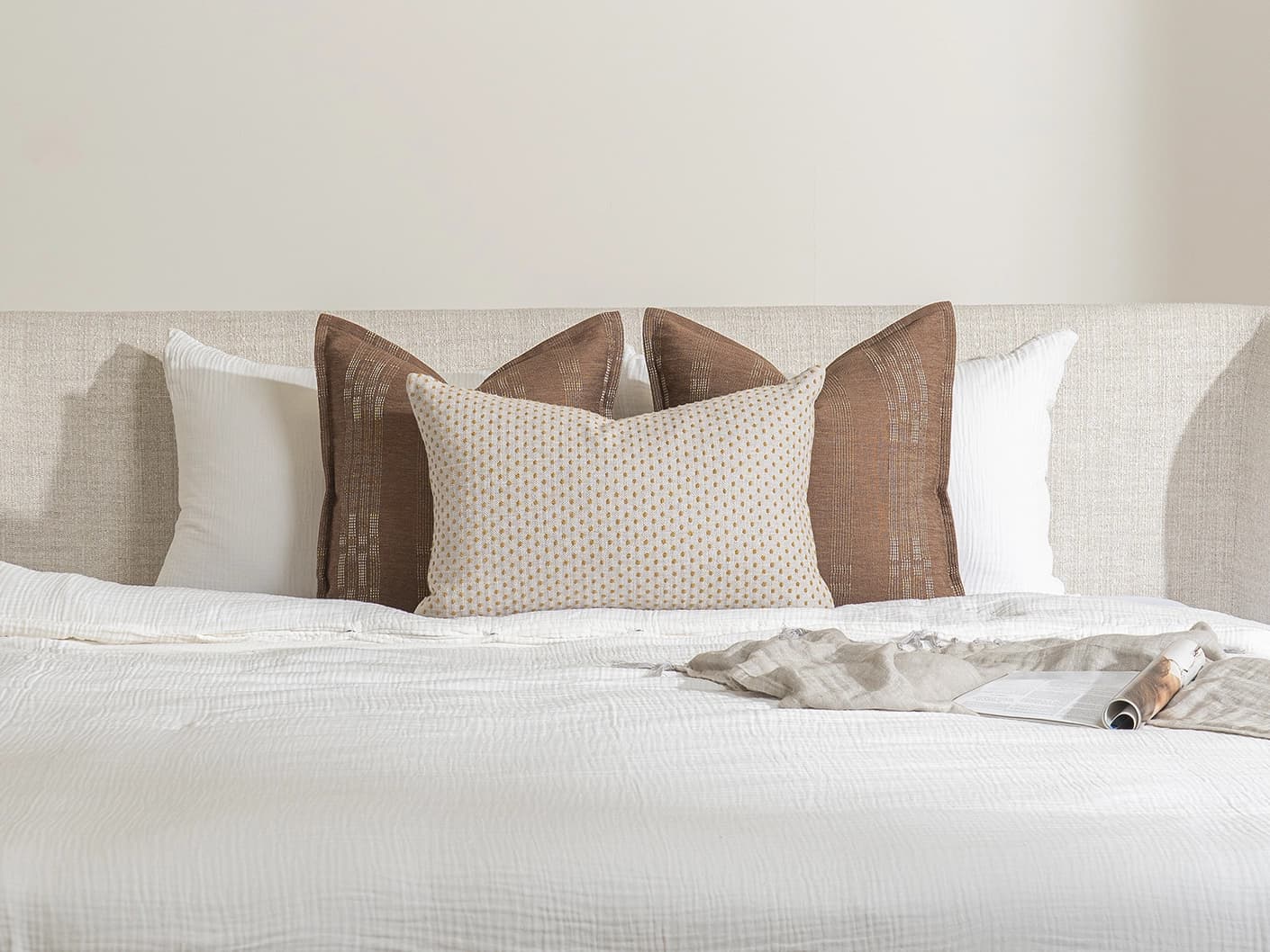 Sam Bundle bundle cushions in brown, orange and beige, shown in a lifestyle front view