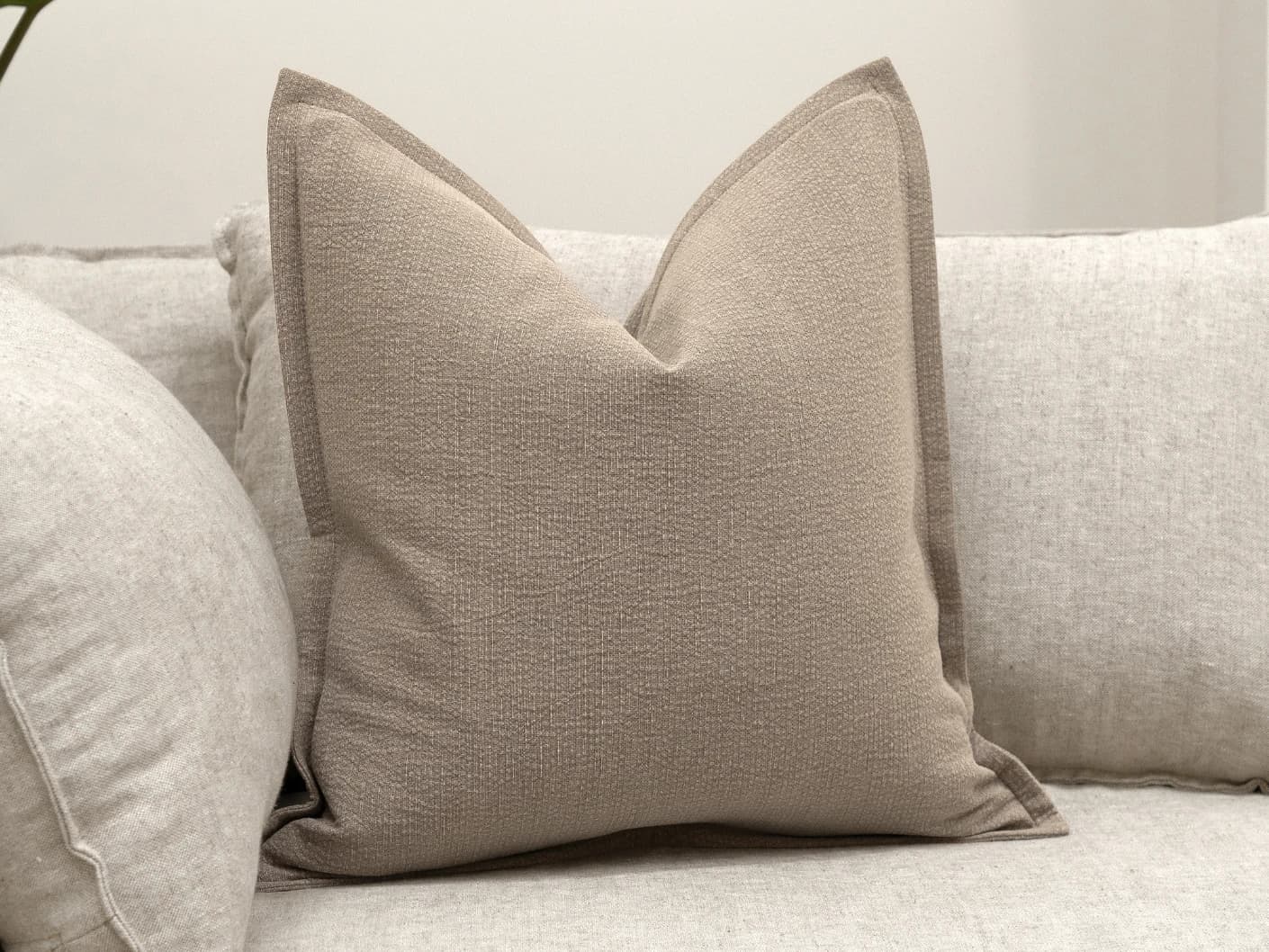 Siena Braun single cushions in beige and grey, shown in a lifestyle front view