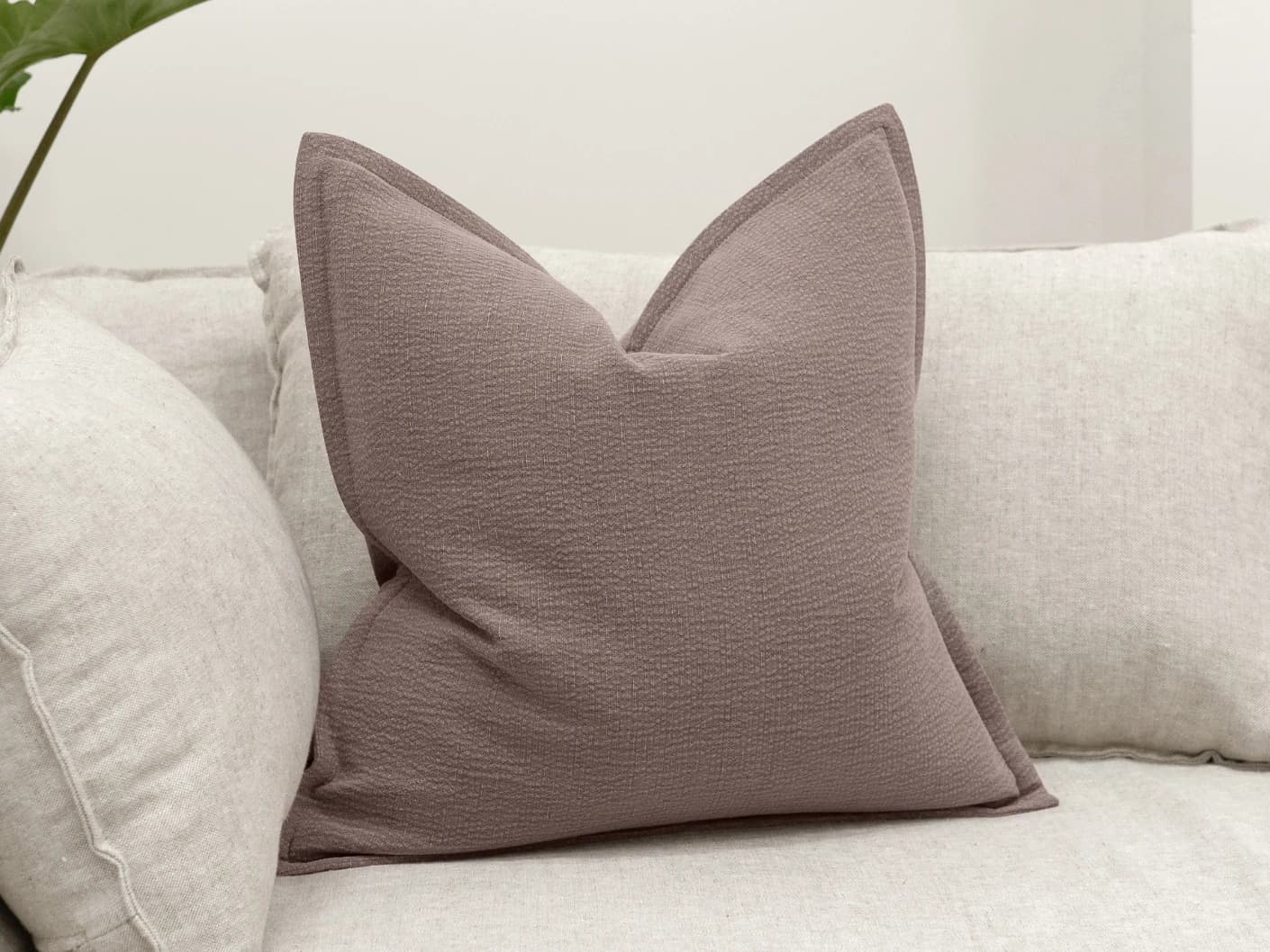 Siena Mauveine single cushions in purple and taupe, shown in a lifestyle front view