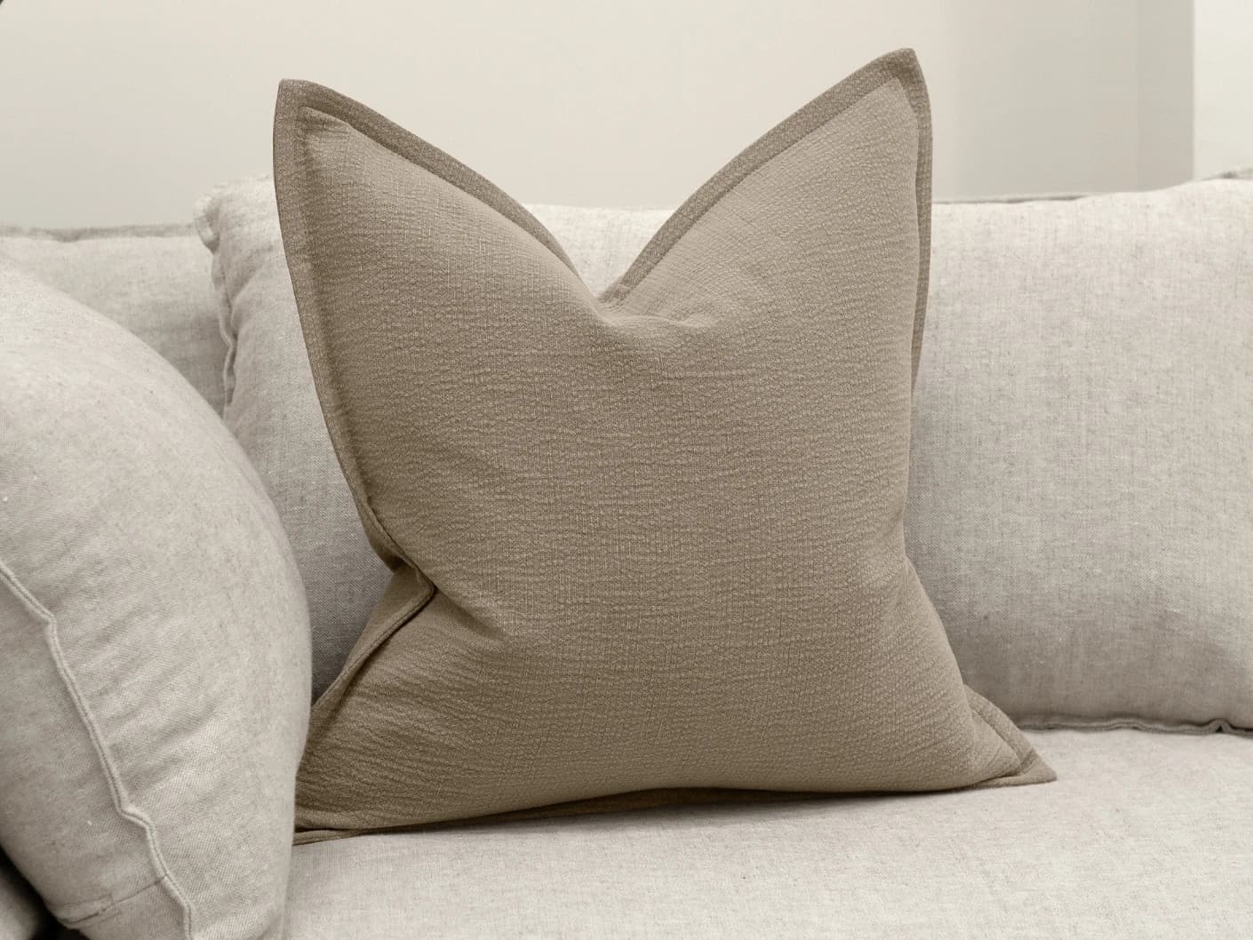 Siena River single cushions in grey, shown in a lifestyle front view