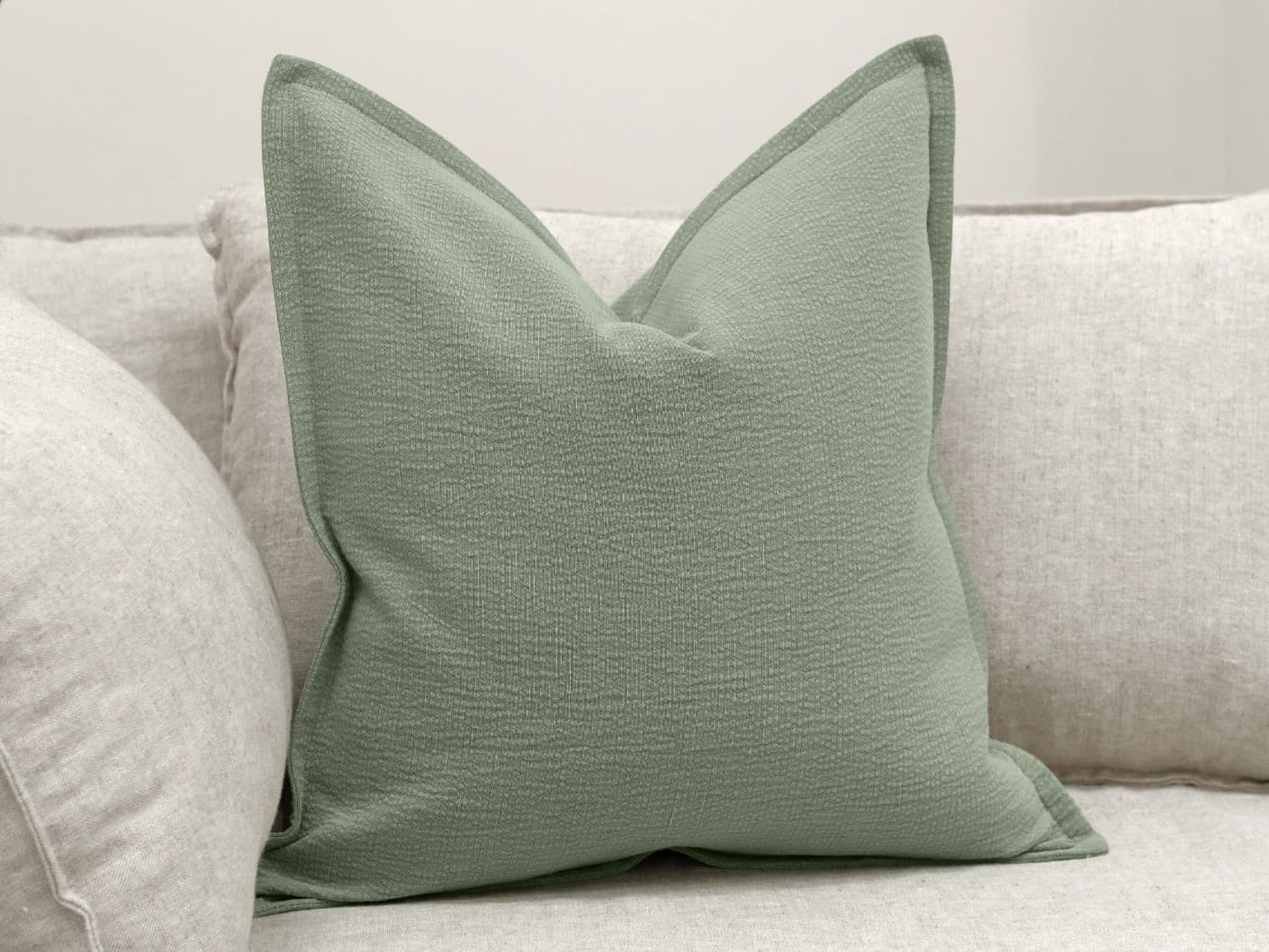 Siena Willow single cushions in green, shown in a lifestyle front view