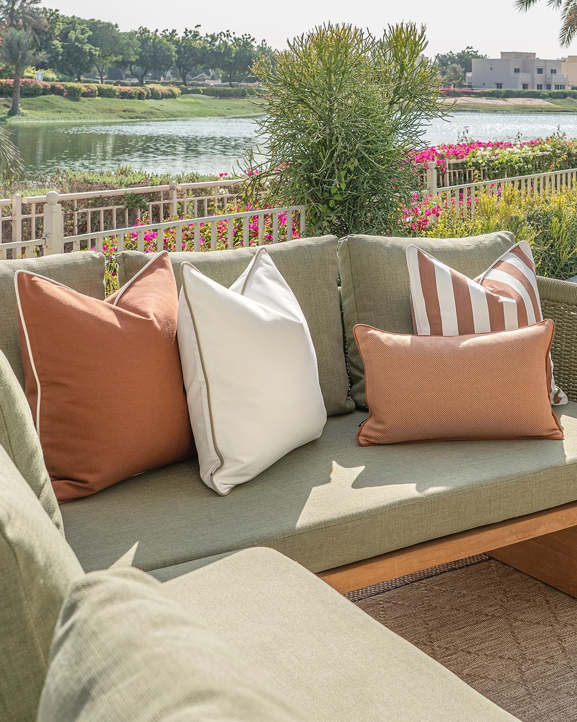 Sio Bundle cushion in rust and ivory, shown in a lifestyle left view as image 2