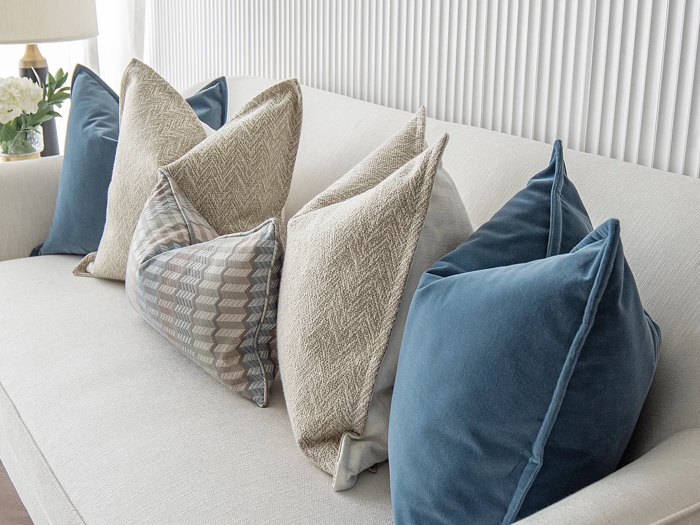 Stephan Bundle bundle cushions in silver, blue and beige, shown in a lifestyle front view