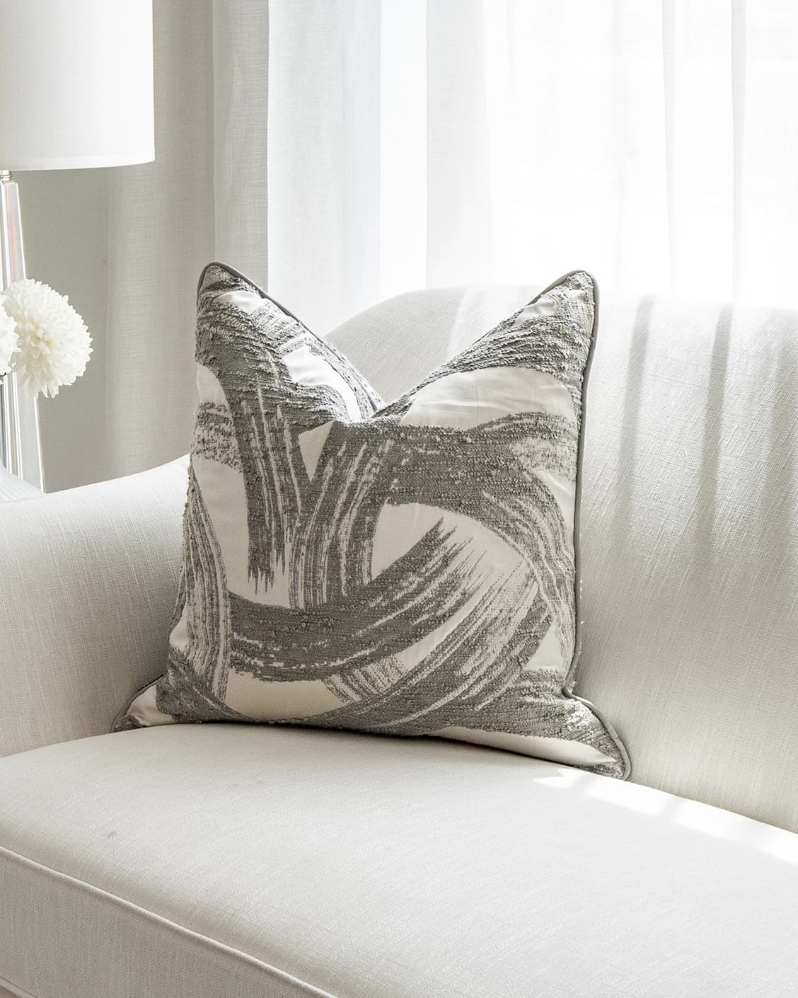 Tanya Laurent cushion in white and grey, shown in a lifestyle front view as image 2
